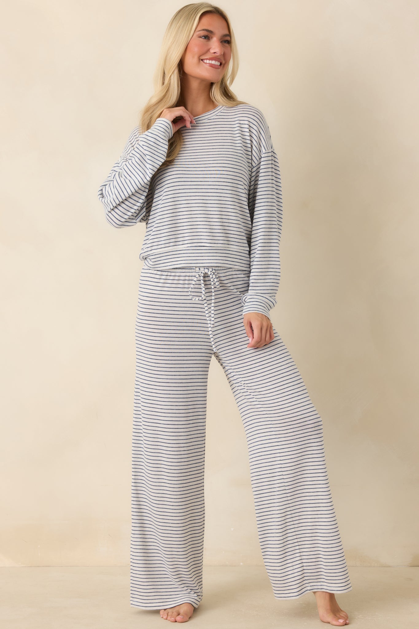 Navy striped wide leg pants featuring a relaxed silhouette, high-rise waistband, and soft brushed sweater knit fabric.