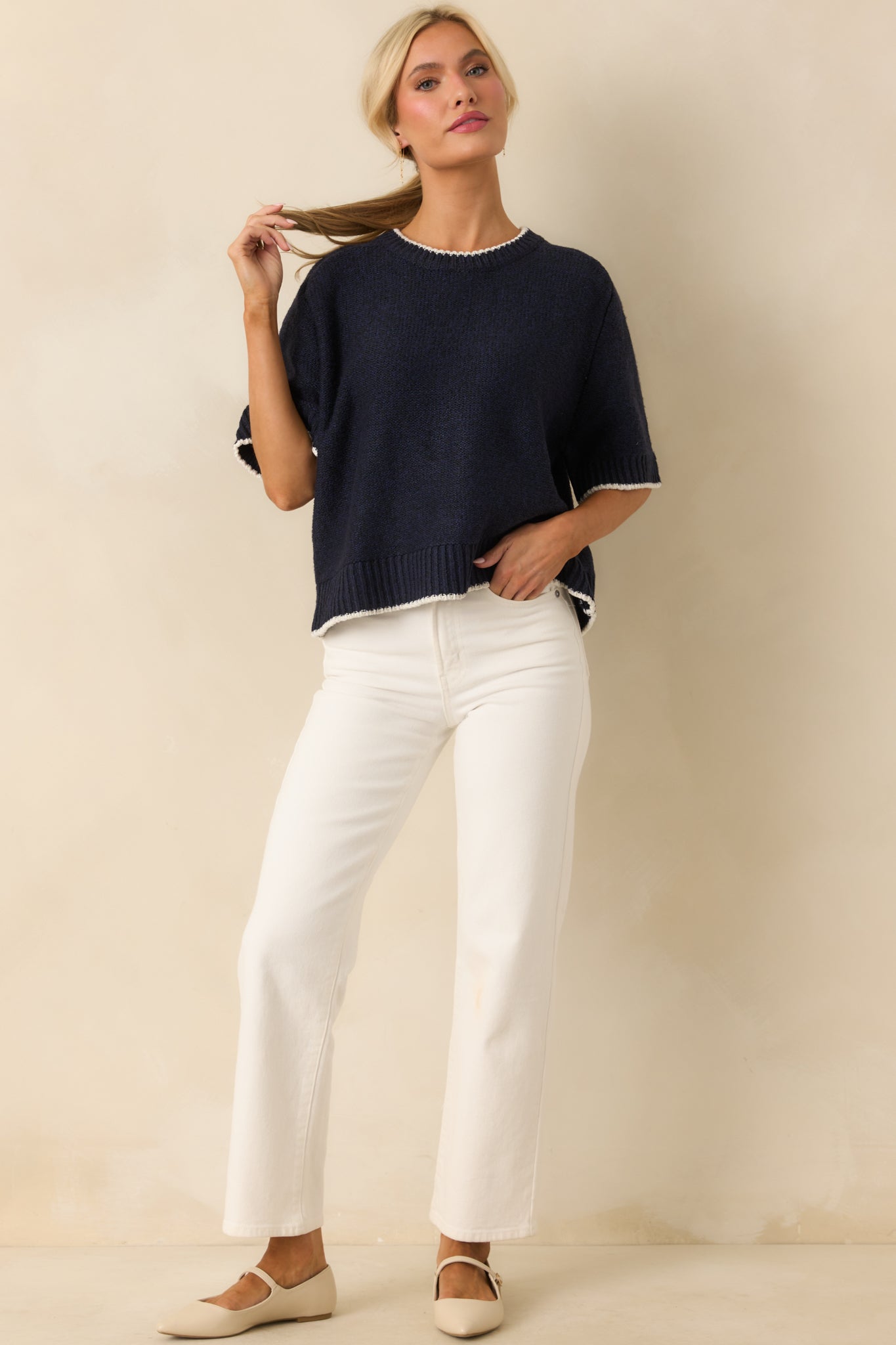 Navy sweater displayed front facing, highlighting the oversized fit and short sleeves with contrast trim.
