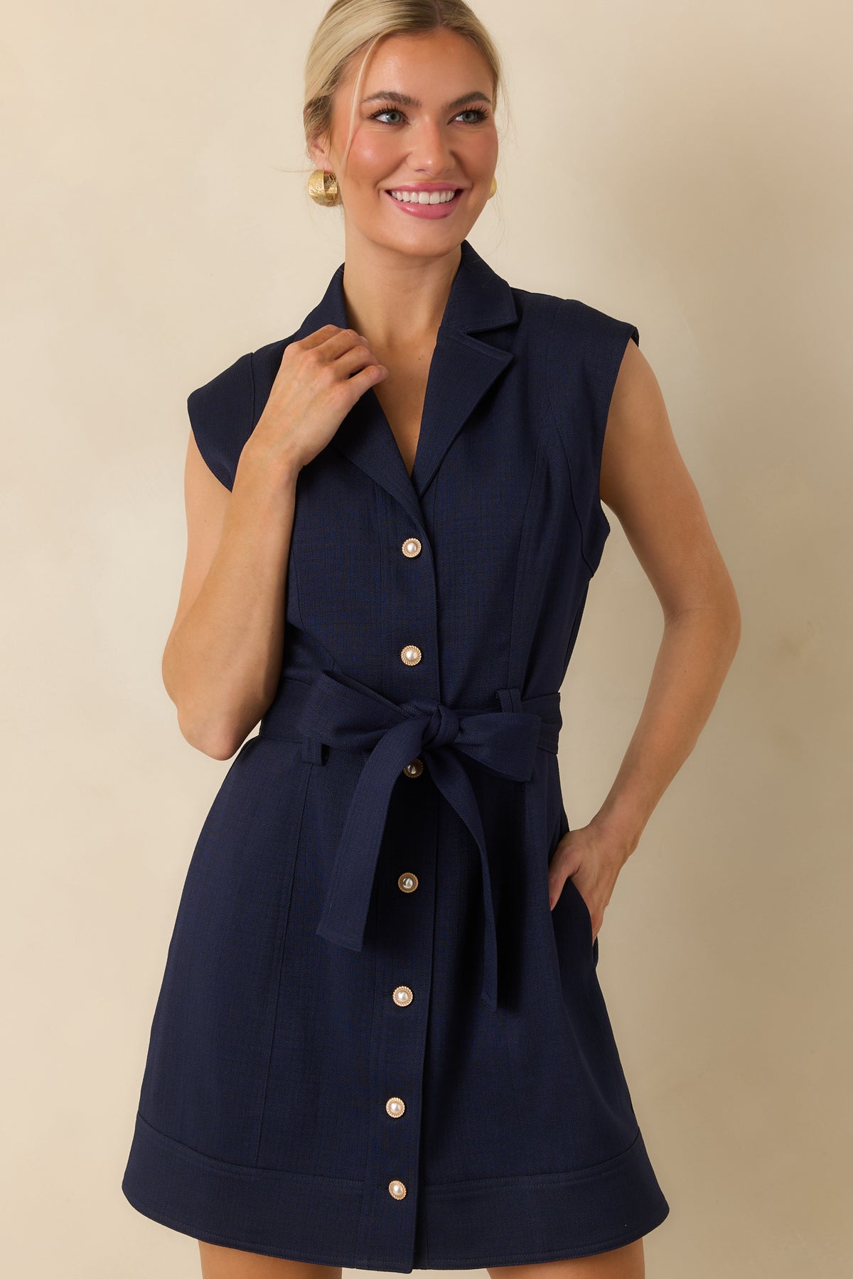 Textured navy mini dress featuring princess seams, a removable self-tie belt, side pockets, and a wide banded hem.