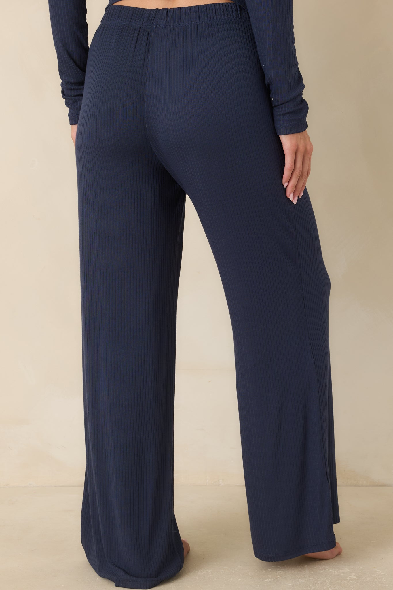 Rear view of the navy wide leg pants featuring a relaxed fit, elastic waistband, and clean ribbed finish.
