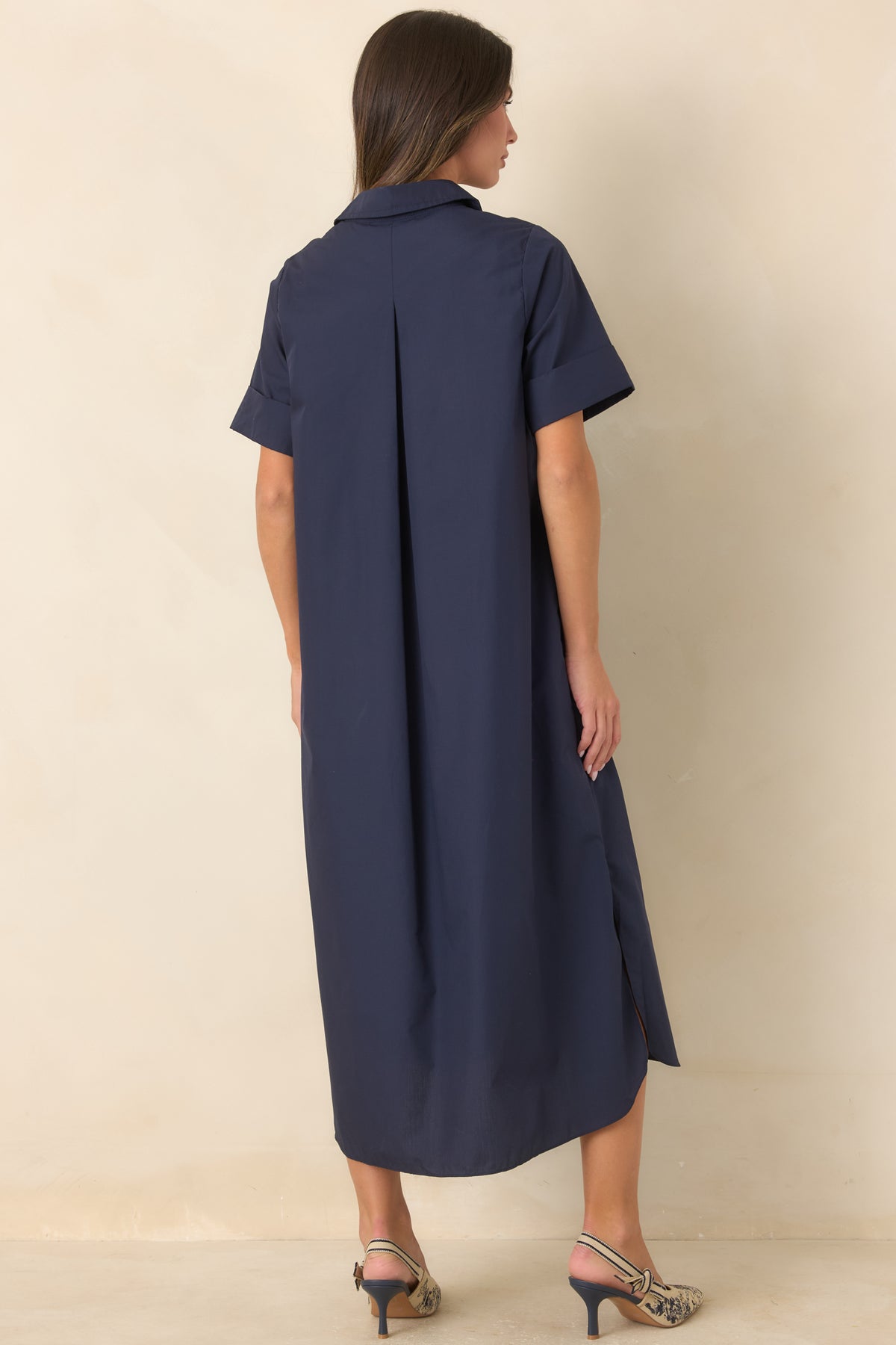 Rear of the navy woven maxi dress showing the relaxed A-line silhouette, rolled short sleeves, and flowing skirt.
