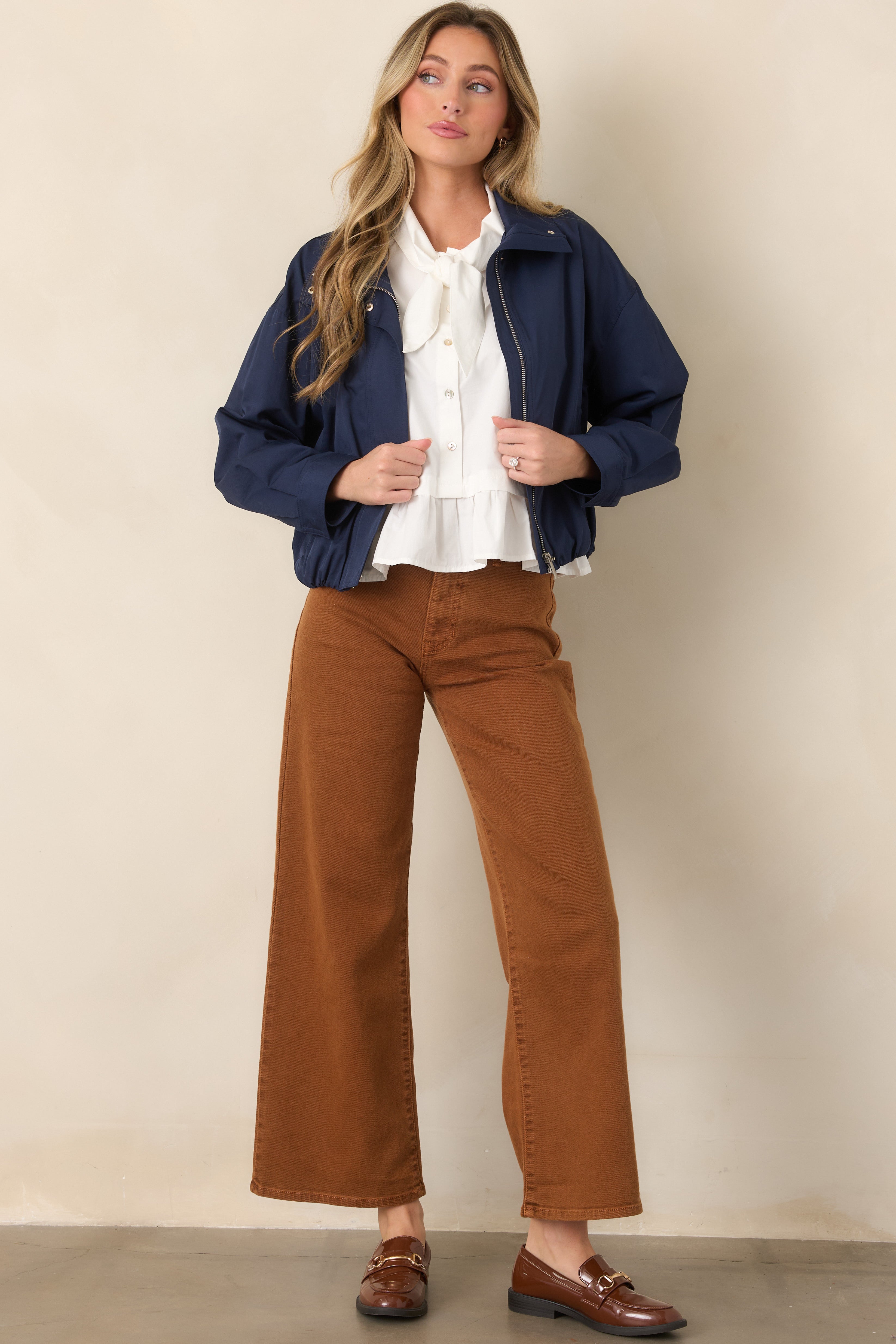 Navy bomber jacket with a smooth woven shell, zip-front closure, stand collar, dropped shoulders, and relaxed slightly cropped silhouette.