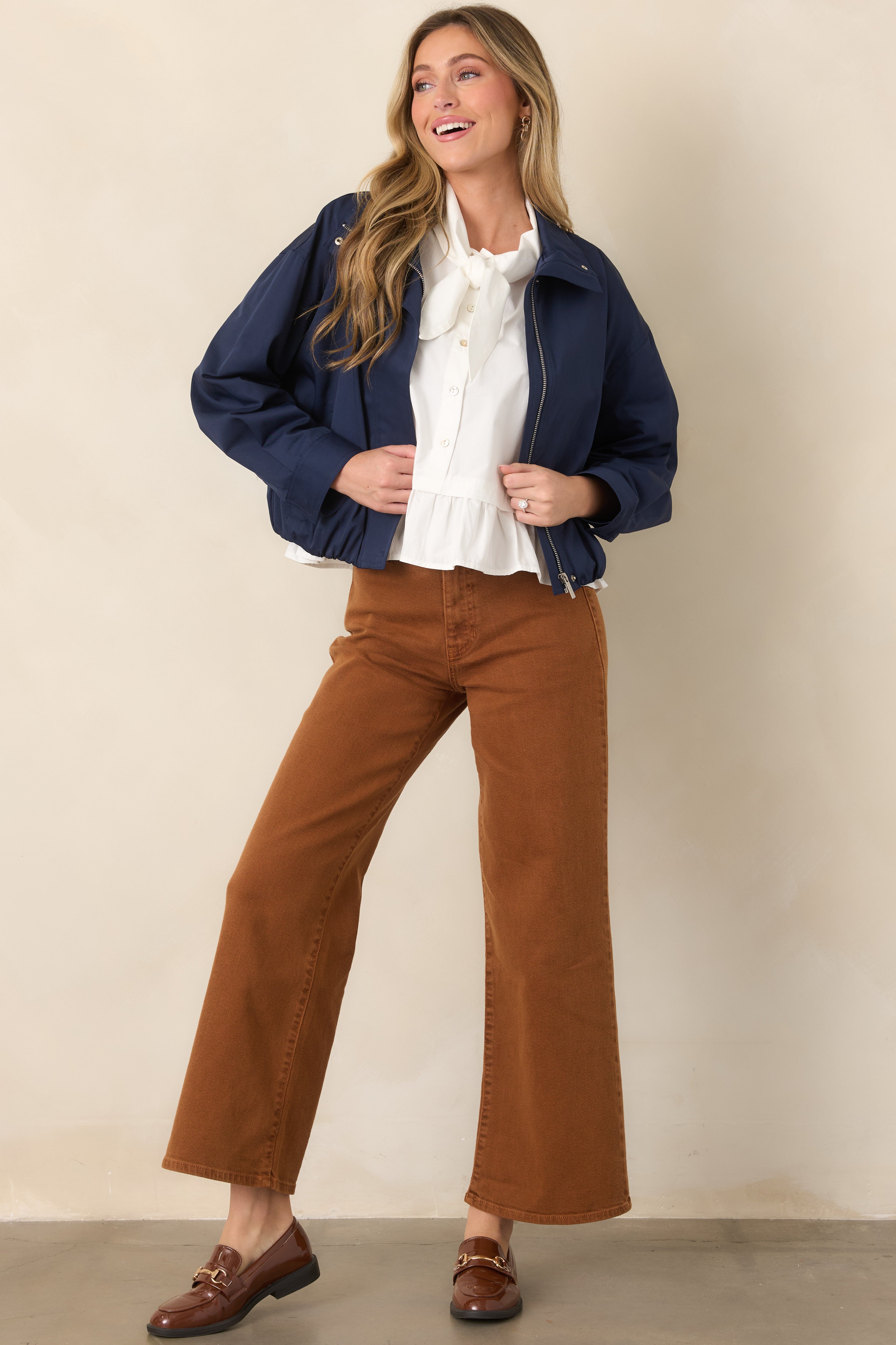 Lightweight navy bomber jacket with a zip-front design, stand collar, welt pockets, and elasticized hem for a softly structured finish.