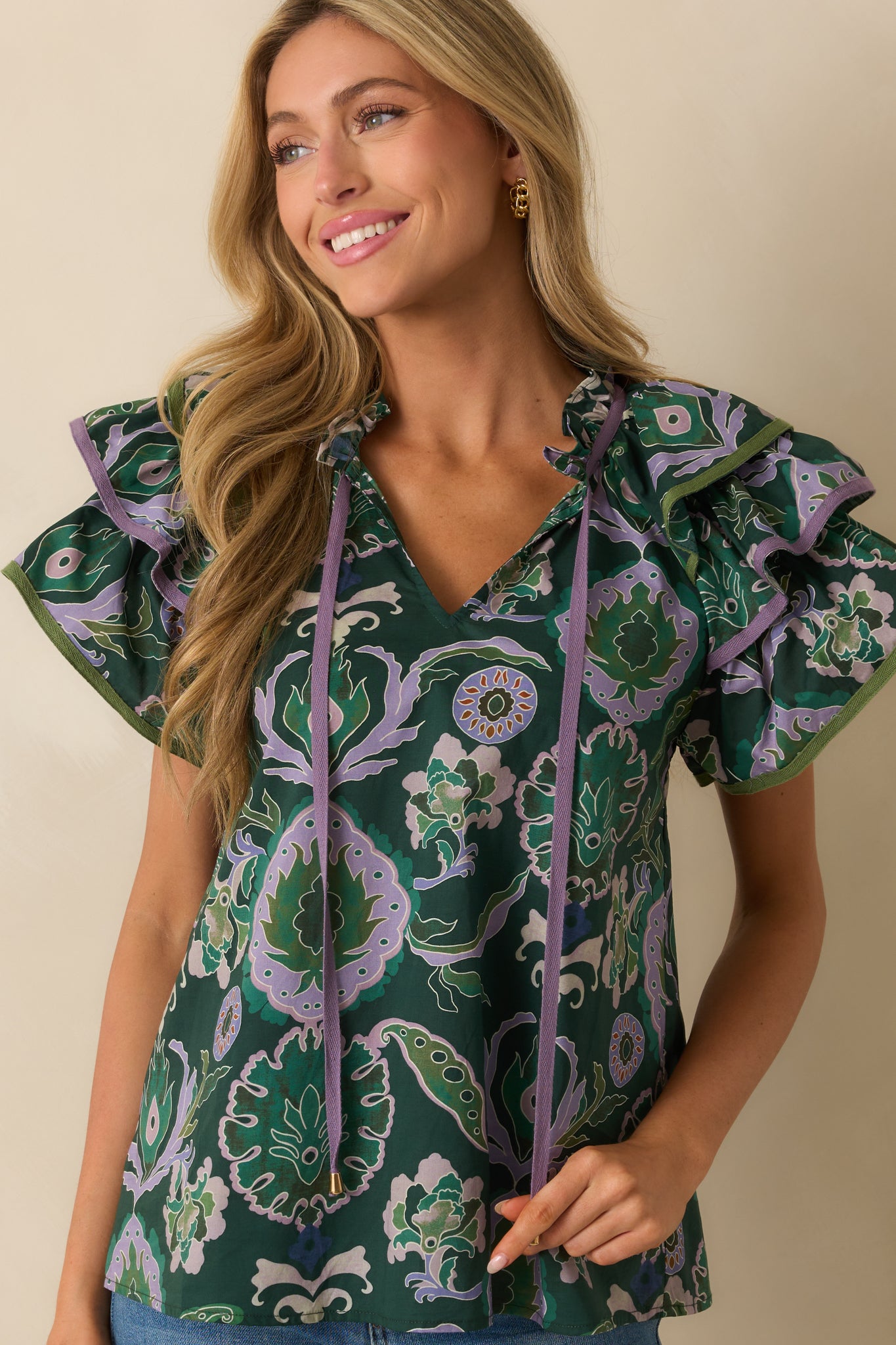 Close crop of neckline and upper chest, emphasizing ruffle trim and self-tie tassels.