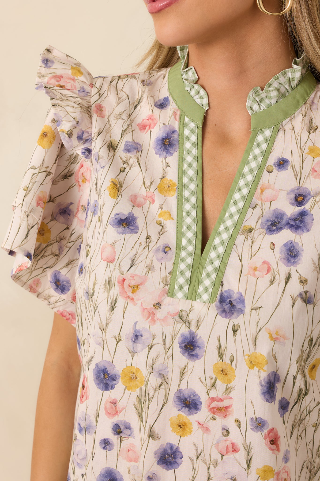 Tight detail of the neckline showing green trim and gingham texture on lightweight woven cotton.