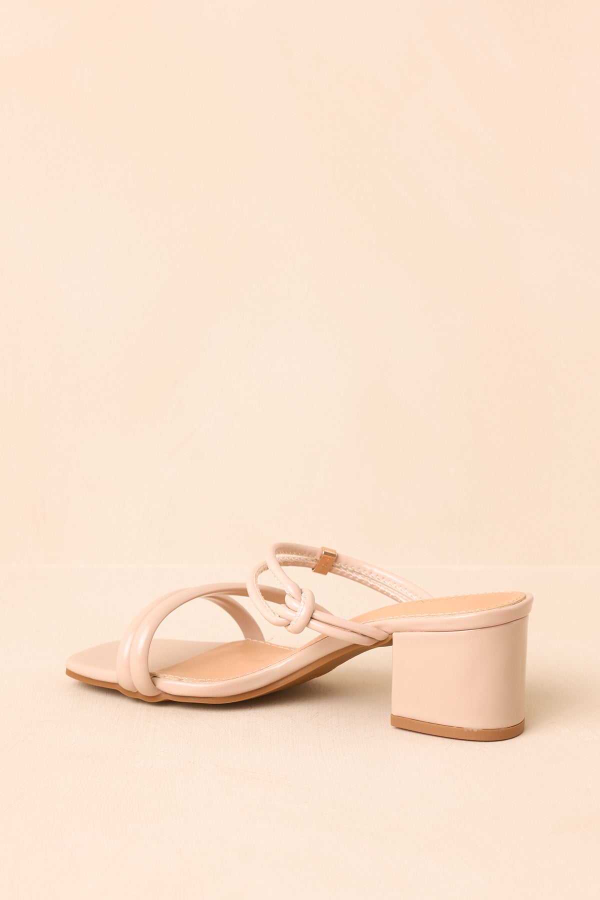 Neutral beige heels featuring smooth toe straps and a structured covered heel.