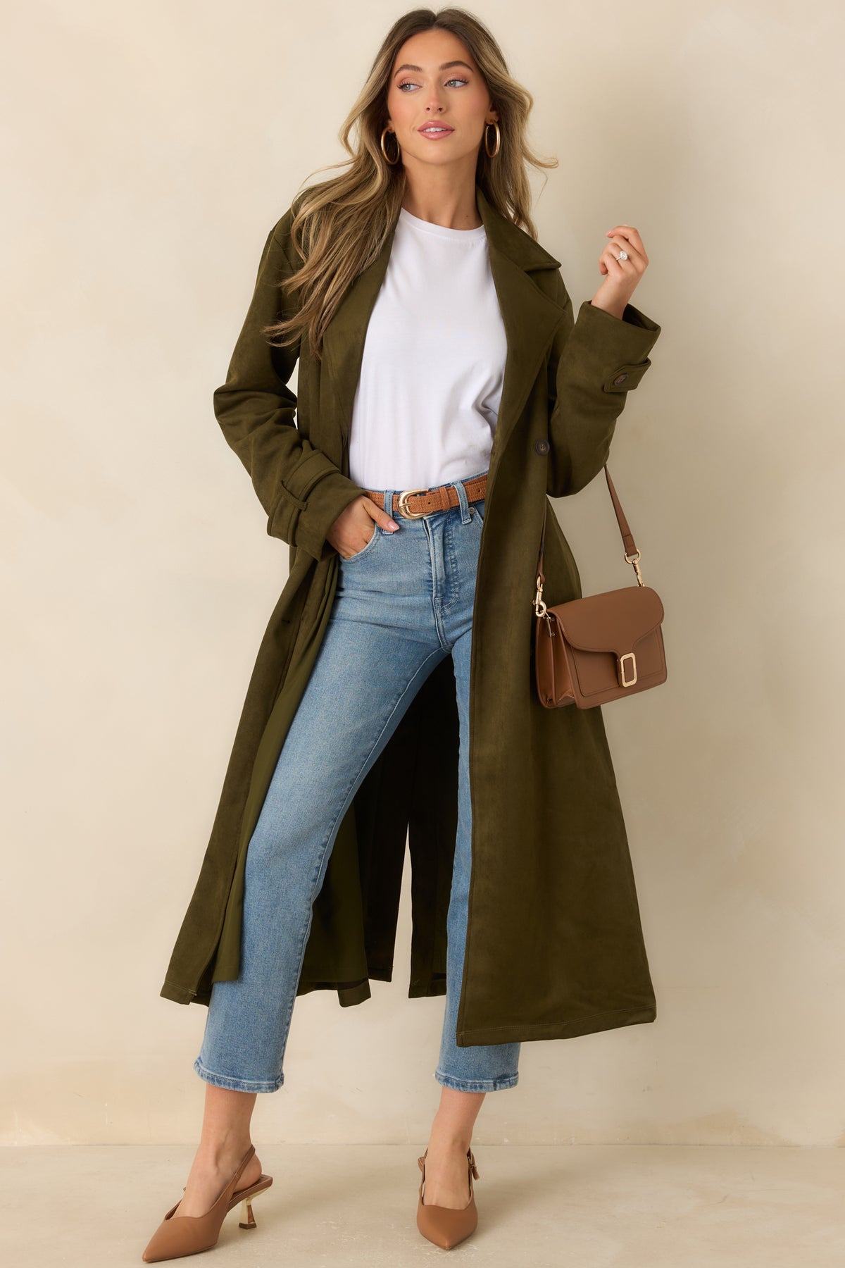 Long coat with a notched lapel, defined waist, and buttoned front closure.