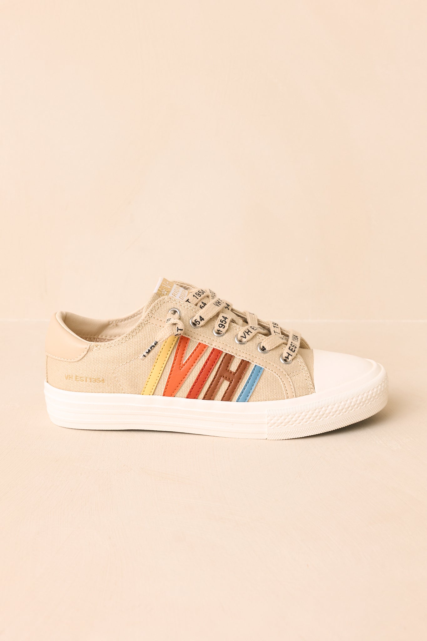 Pair of nude canvas lace-up sneakers featuring a classic low-top silhouette and vibrant faux leather overlays displayed on a beige background.