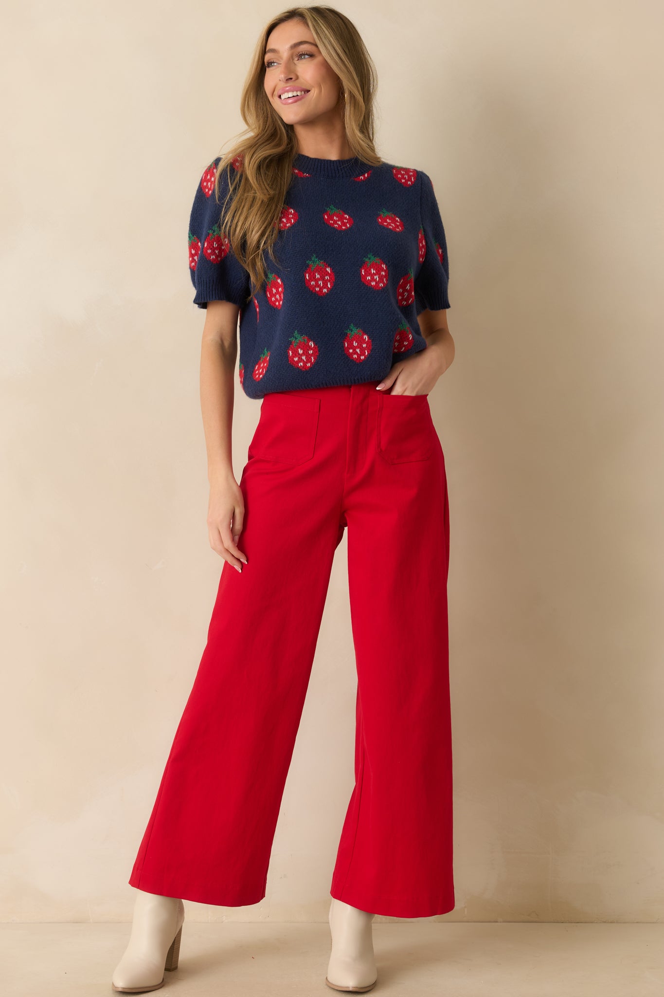 Navy short-sleeve sweater with red strawberry intarsia pattern, relaxed fit, and ribbed crew neckline.