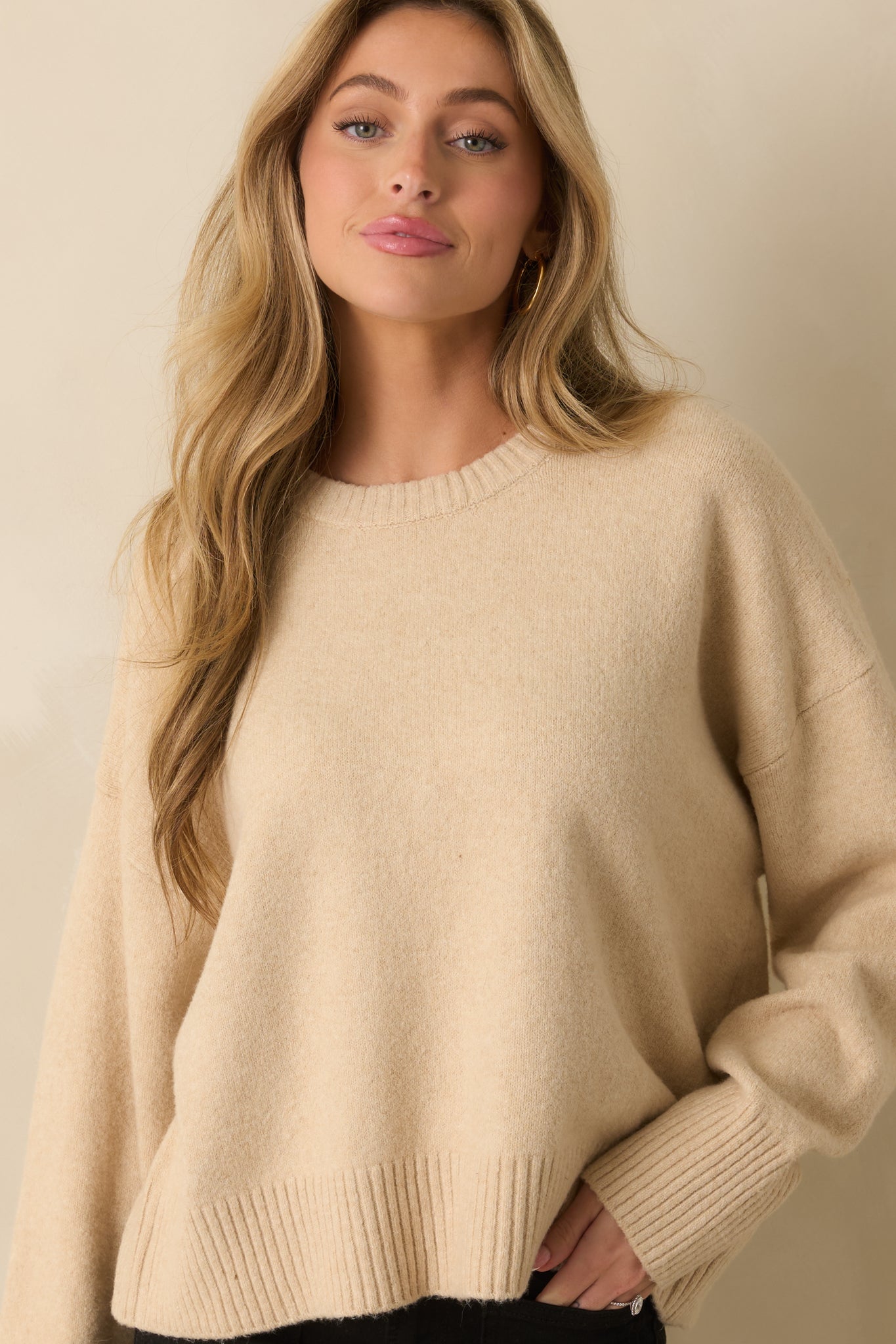 Cropped front view focusing on the upper portion of the sweater, including neckline and shoulder seam.