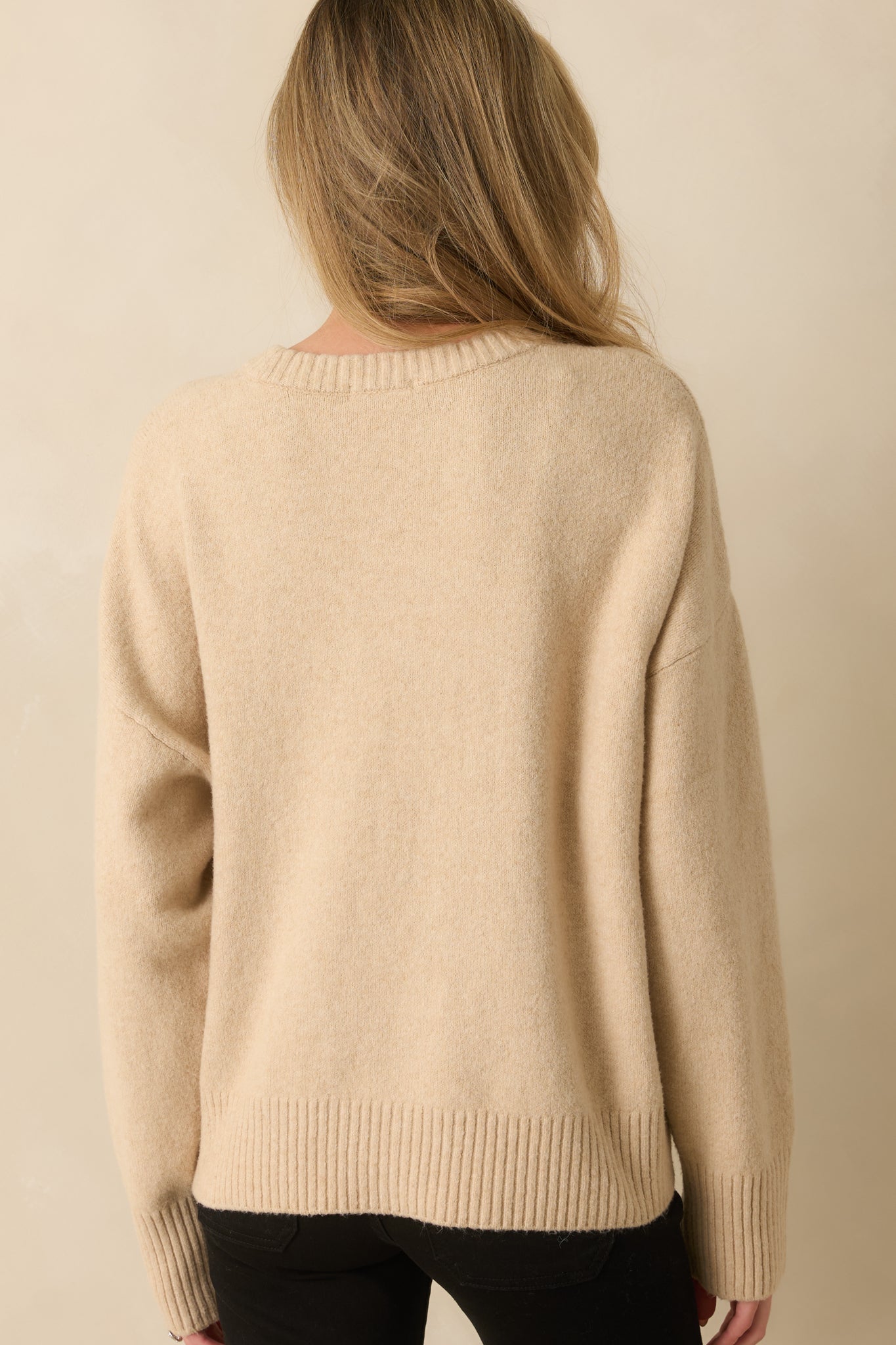 Back view of the sweater showing straight hem, long sleeves, and smooth knit finish.