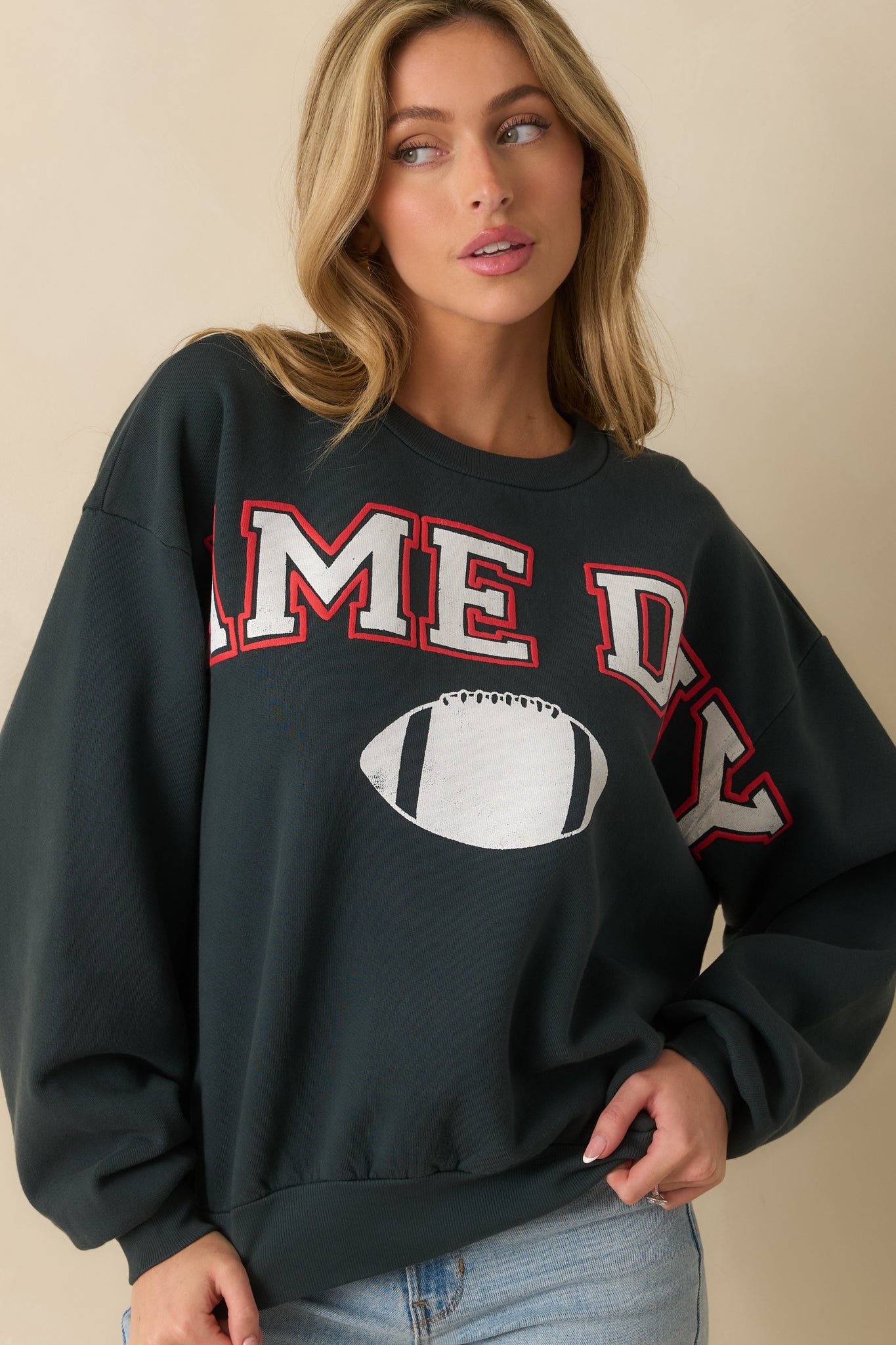 Focus on the sweatshirt’s textured cotton knit and collegiate-style graphic details.