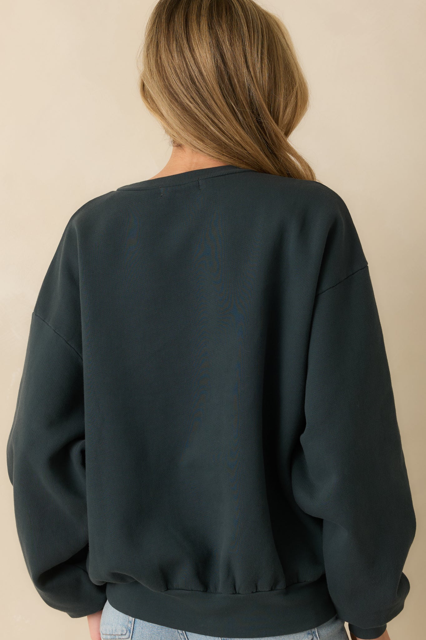 Rear view of the vintage black sweatshirt showing its relaxed fit and simple solid cotton design.