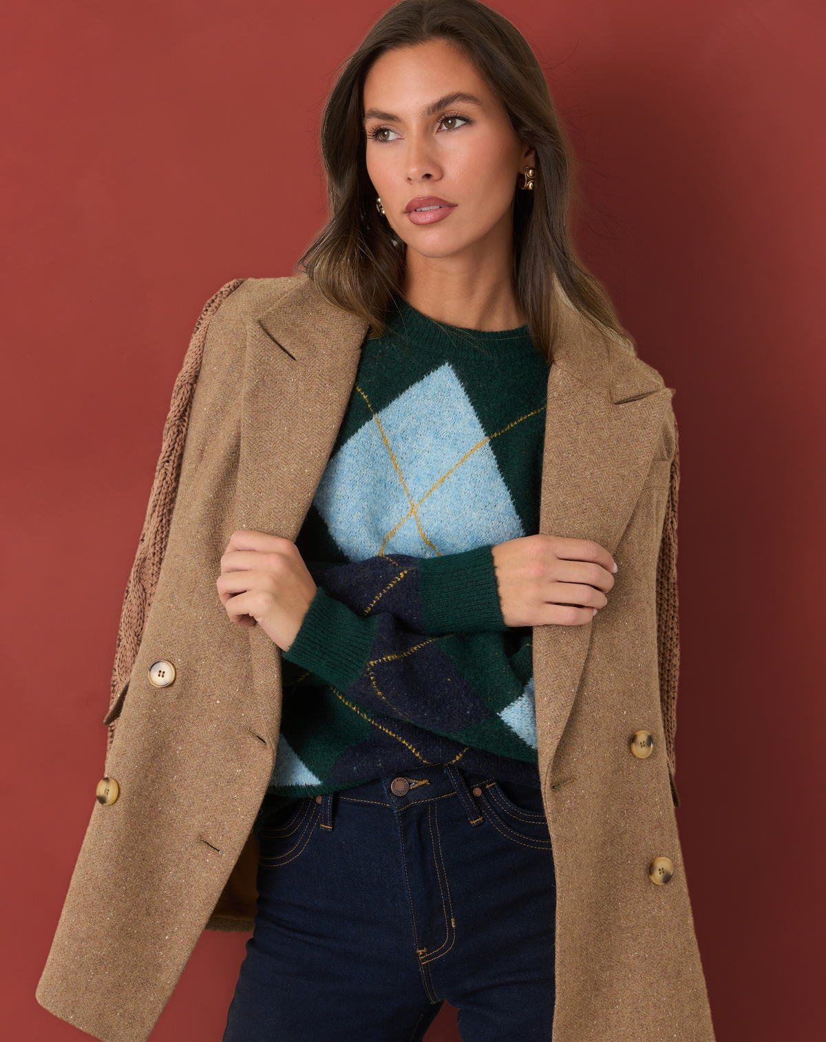 Model wearing a green and blue argyle sweater with a tan blazer.
