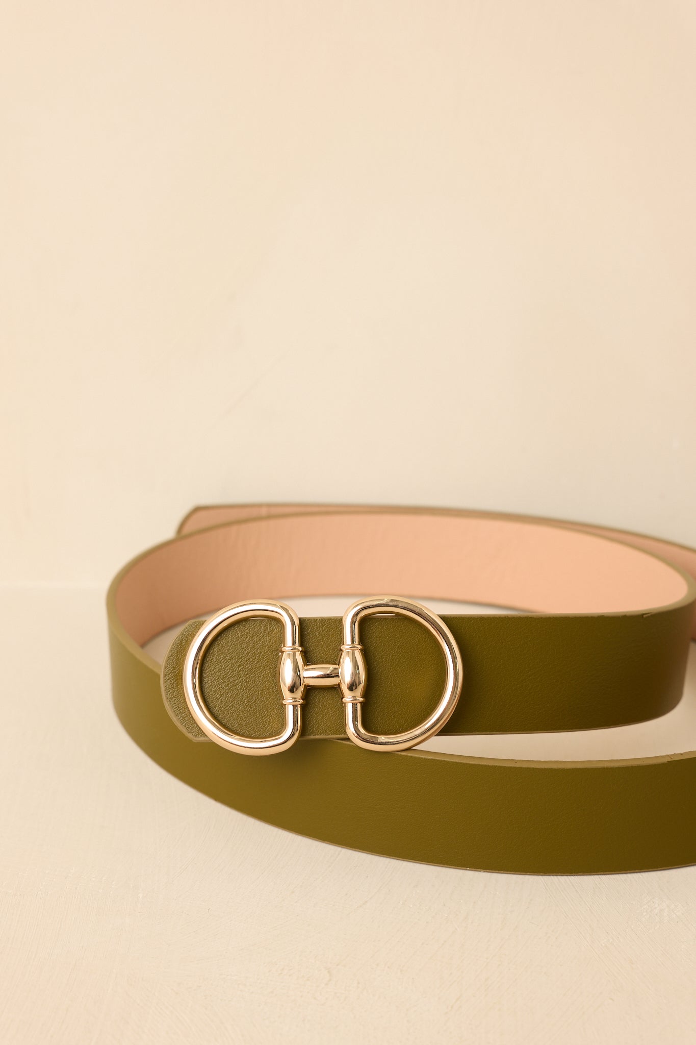 Detailed view of the olive belt strap showcasing the refined finish and polished gold hardware.