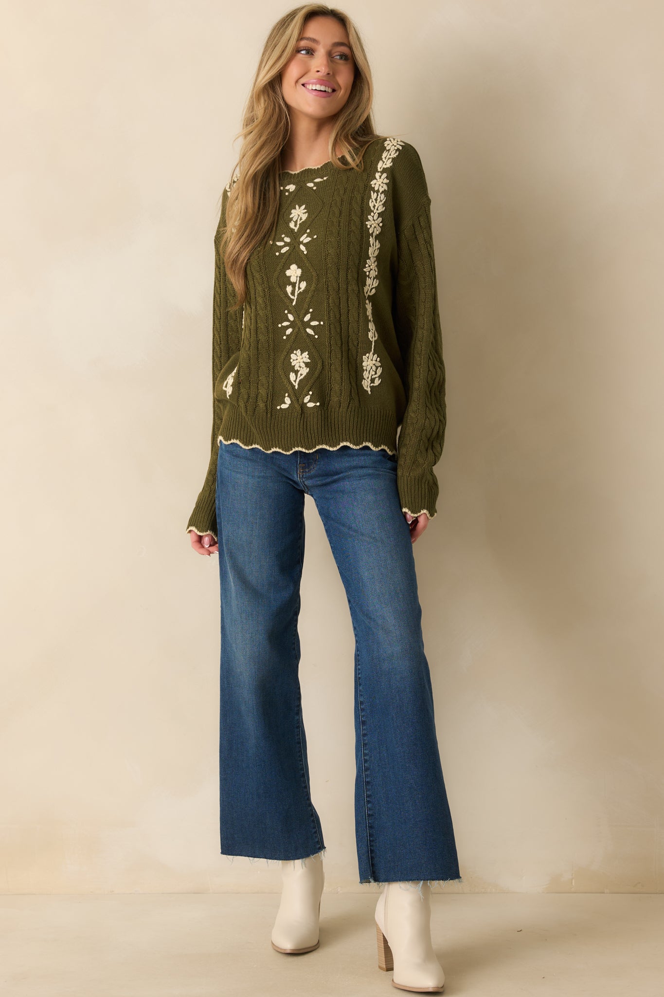 Olive cable knit sweater with ivory floral embroidery across the front and a classic crew neckline.