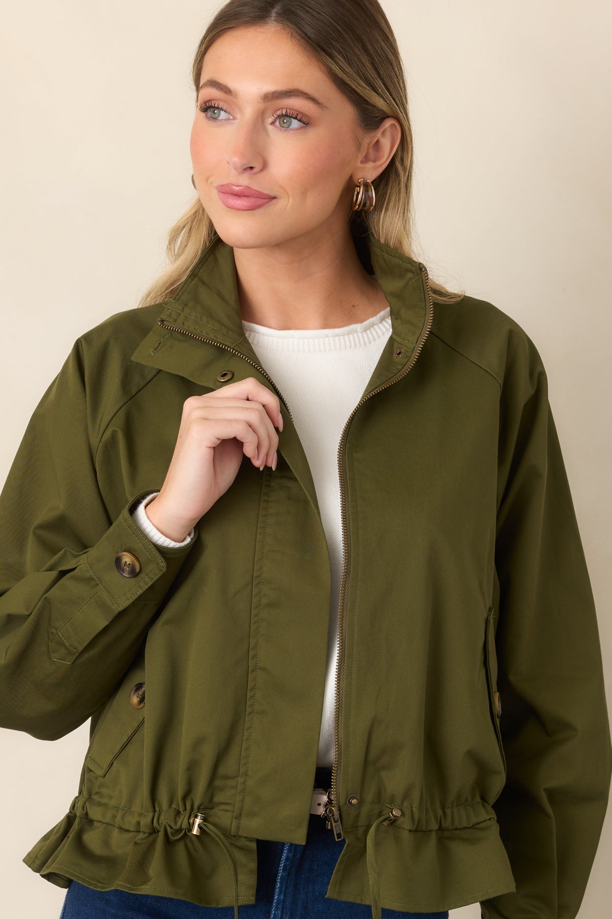 Olive cotton jacket highlighting the functional flap pockets and adjustable drawstring waist.