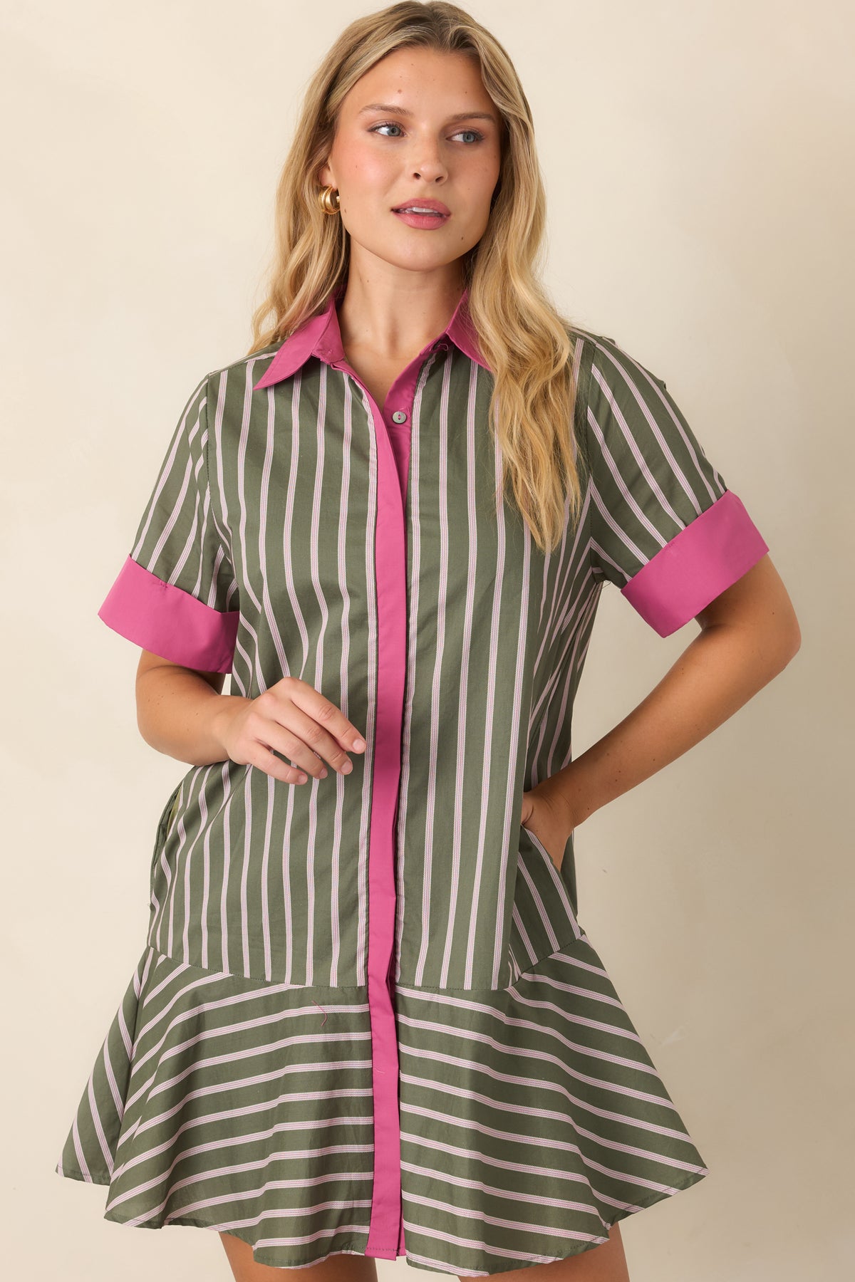 Close view of the olive cotton fabric with fine pale pink stripes and contrasting pink trim along the neckline and sleeves.