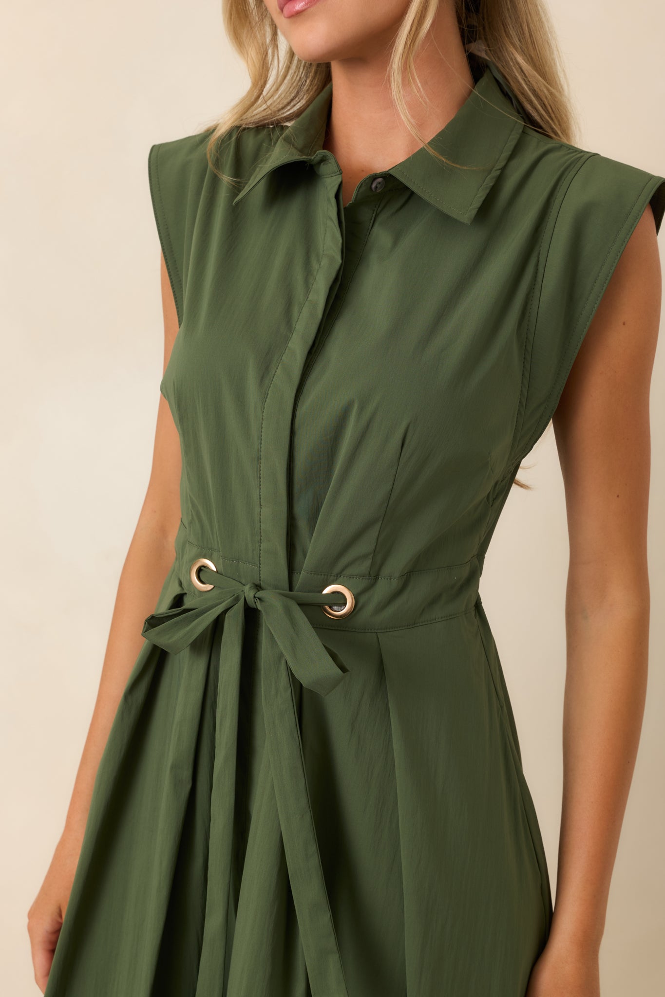 Close-up view of the olive green midi dress highlighting the collar, concealed buttons, and gold-tone belt accents.