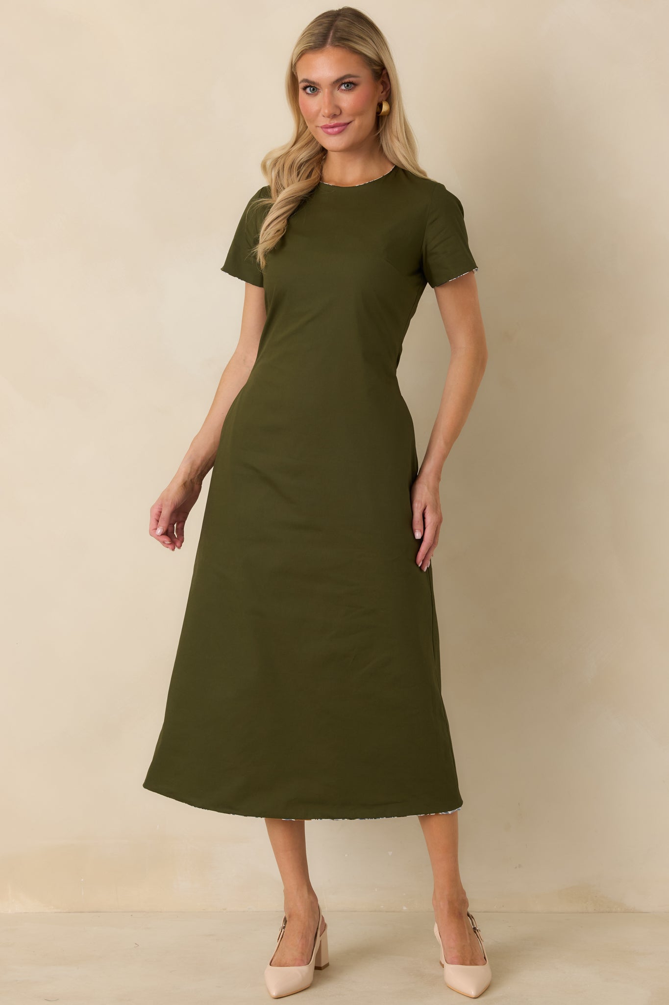 Olive green cotton dress showcasing a polished A-line shape, short sleeves, and convenient side pockets.