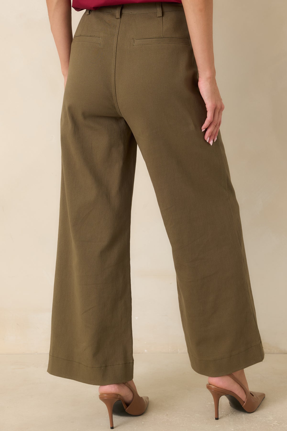 Back view of the olive green cotton pants featuring back welt pockets and a flattering wide leg silhouette.