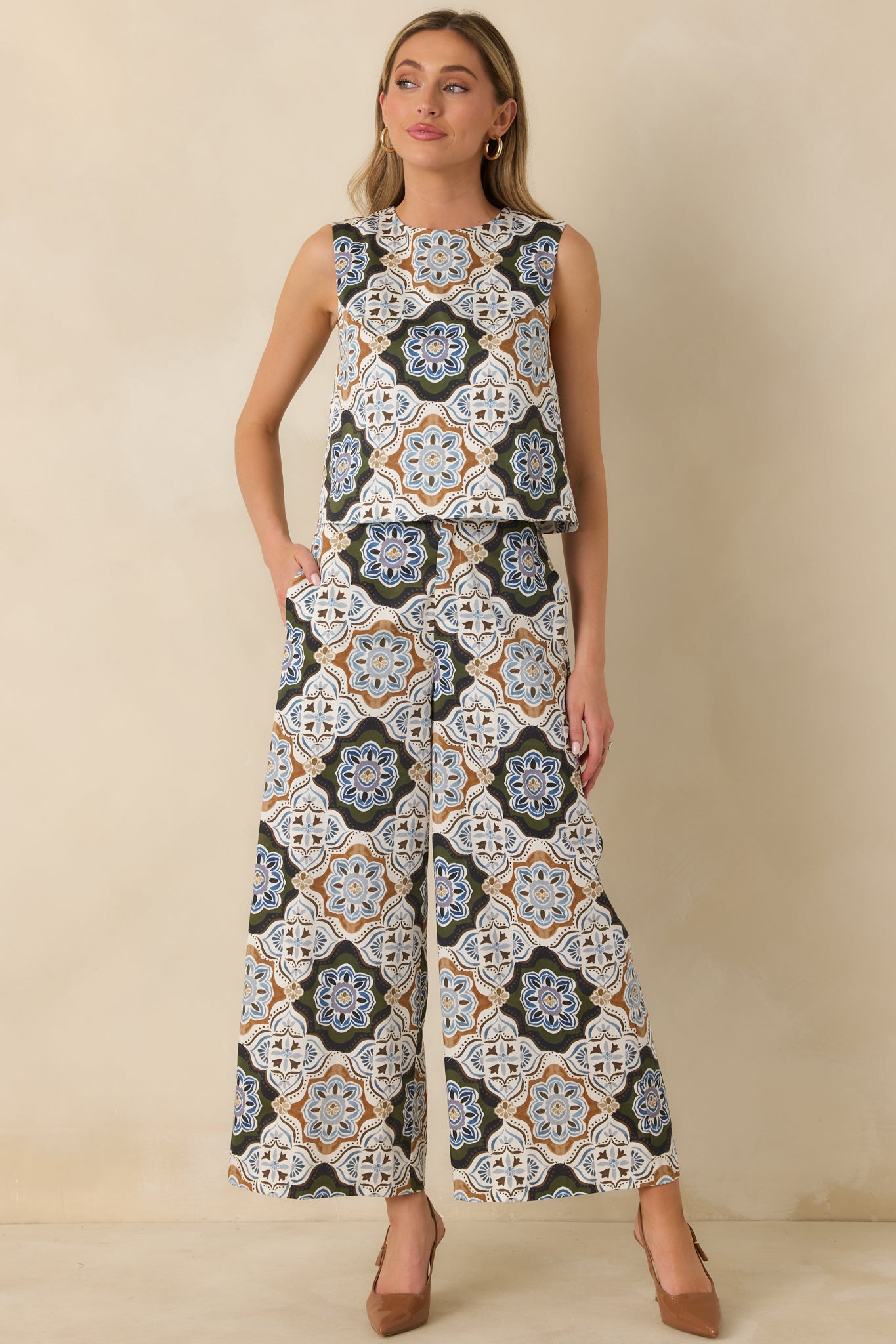 Olive green cotton pants with a bold medallion pattern, cropped length, and fluid wide-leg silhouette.