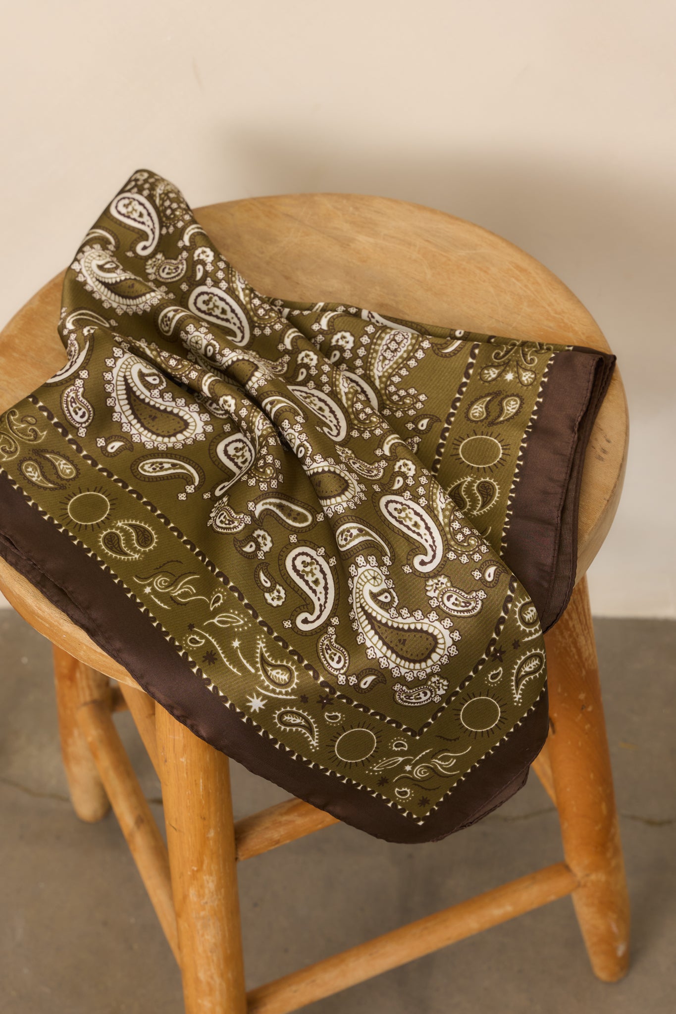 Olive green, ivory, and brown paisley hair scarf with a smooth satin finish and contrasting border.