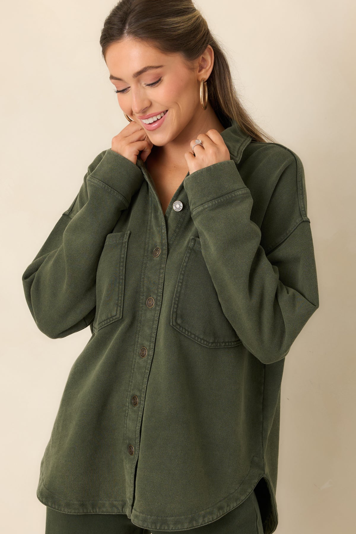 Oversized chest patch pockets add a utility-inspired detail to the olive green jacket.