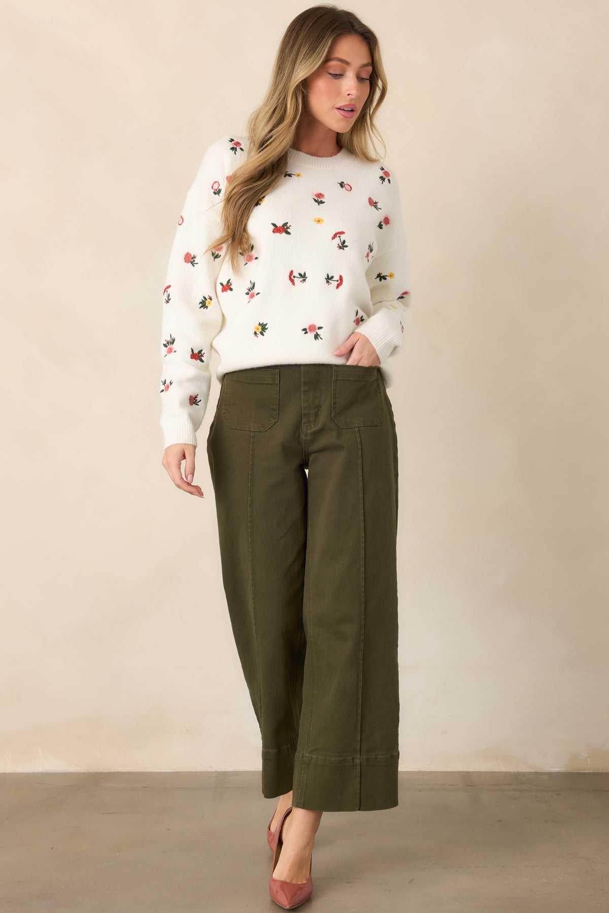 Rich olive green pants designed with crisp center seams, cropped wide legs, oversized pockets, and wide cuffed hems.