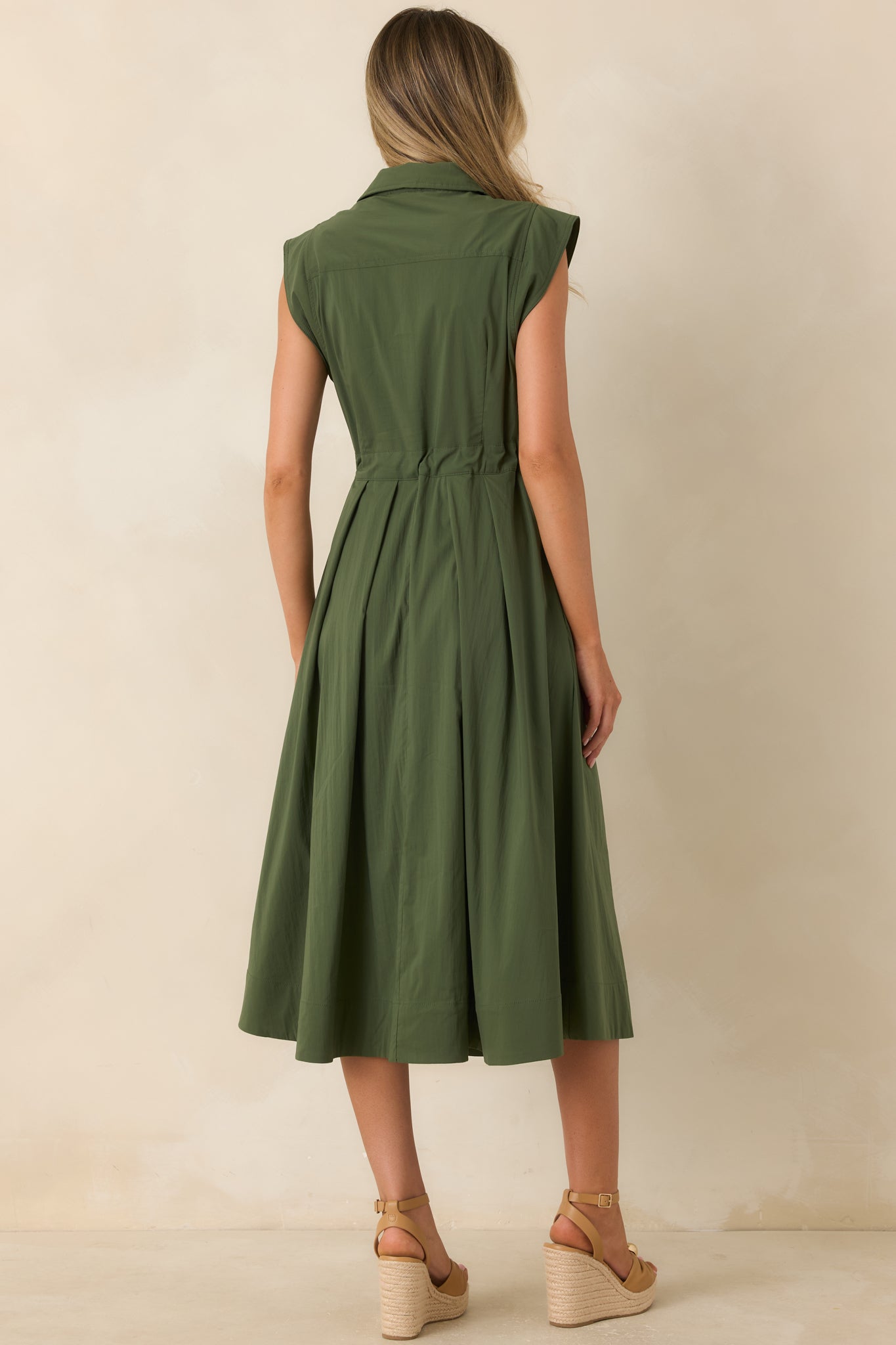Rear view of the olive green cotton poplin midi dress featuring a belted waist and flowing fit-and-flare skirt.