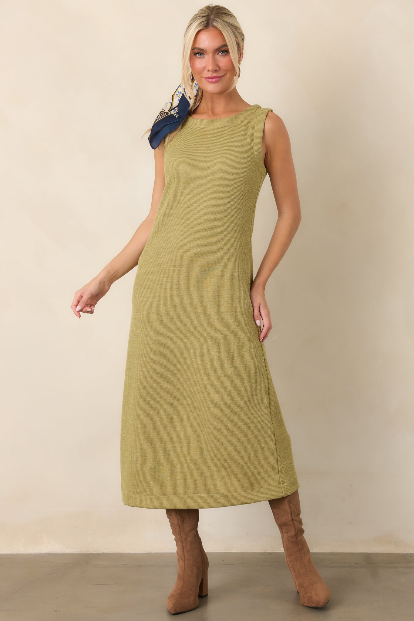 Olive green rib knit midi dress highlighting its sleek sleeveless profile, softly rounded neckline, and textured vertical knit pattern.