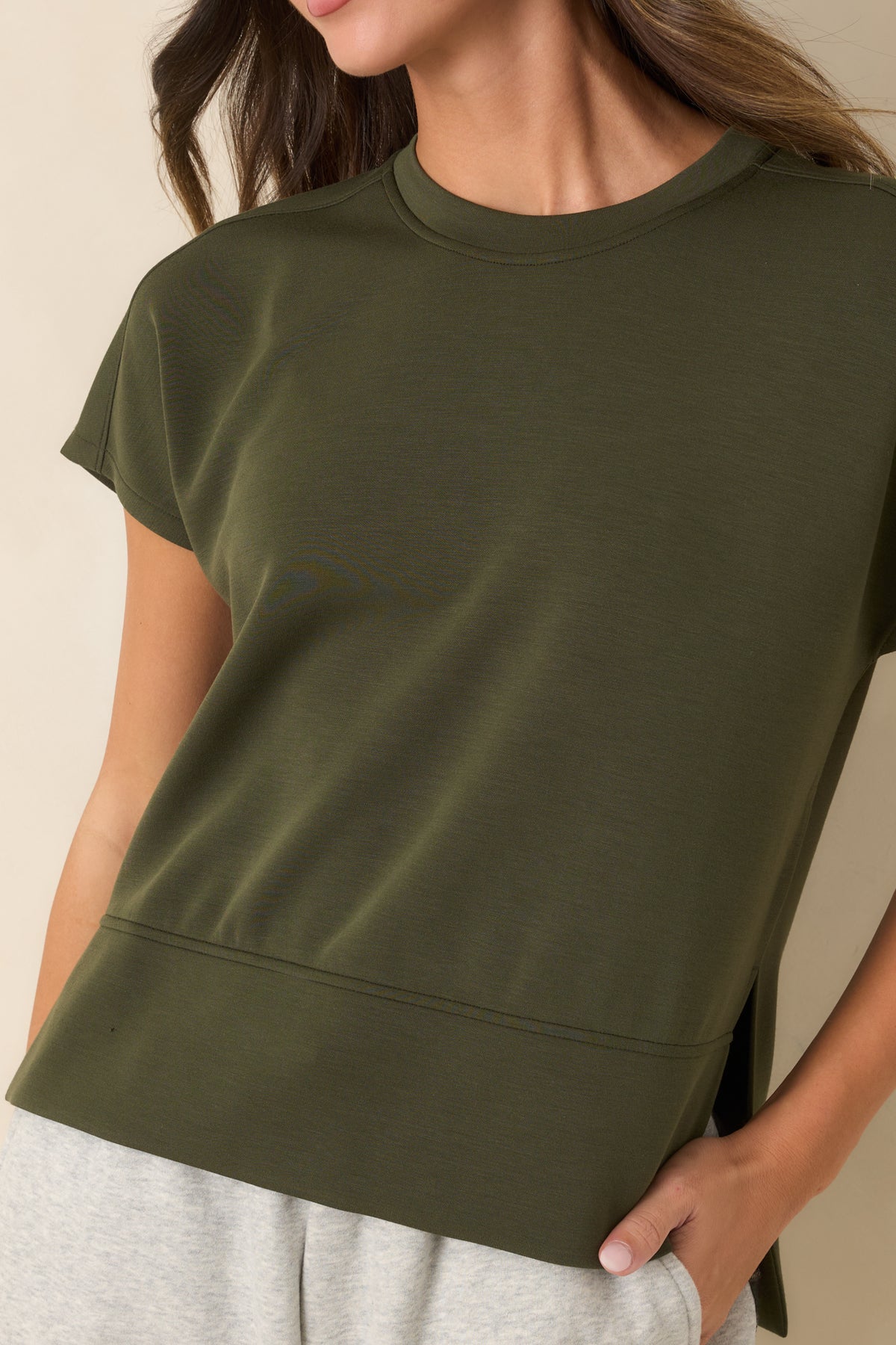 Close-up of the crew neckline, smooth spacer fabric, and short sleeve construction.
