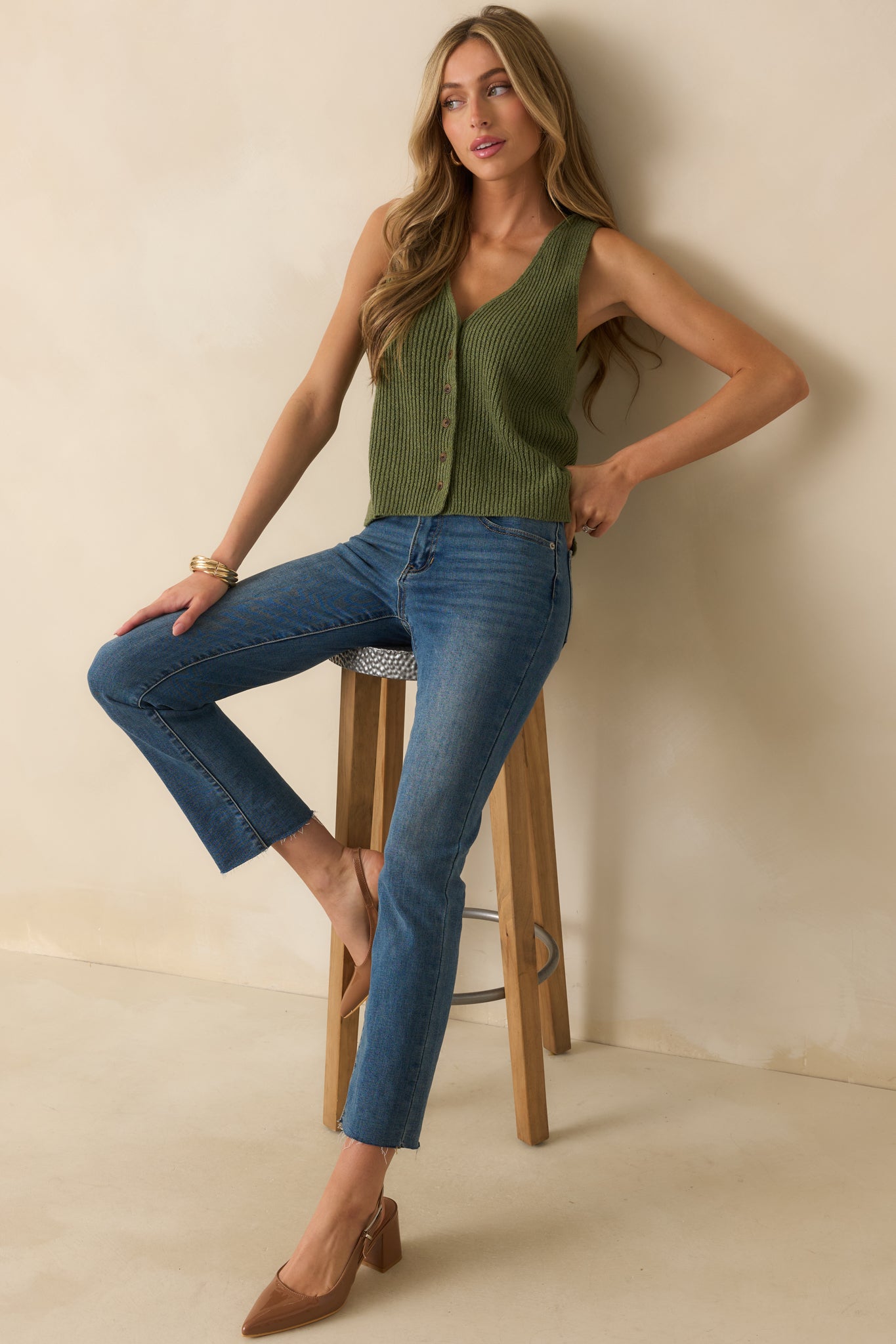 Olive green sweater vest with a v-neckline, sleeveless cut, and relaxed fit.