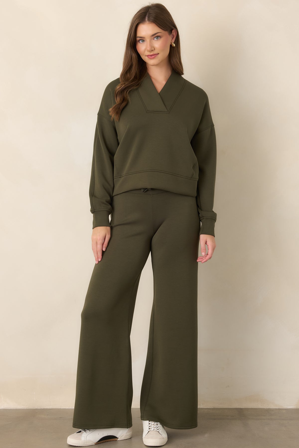 Olive-green long-sleeve top defined by a wide V-neck collar, dropped shoulders, and softly structured relaxed fit.