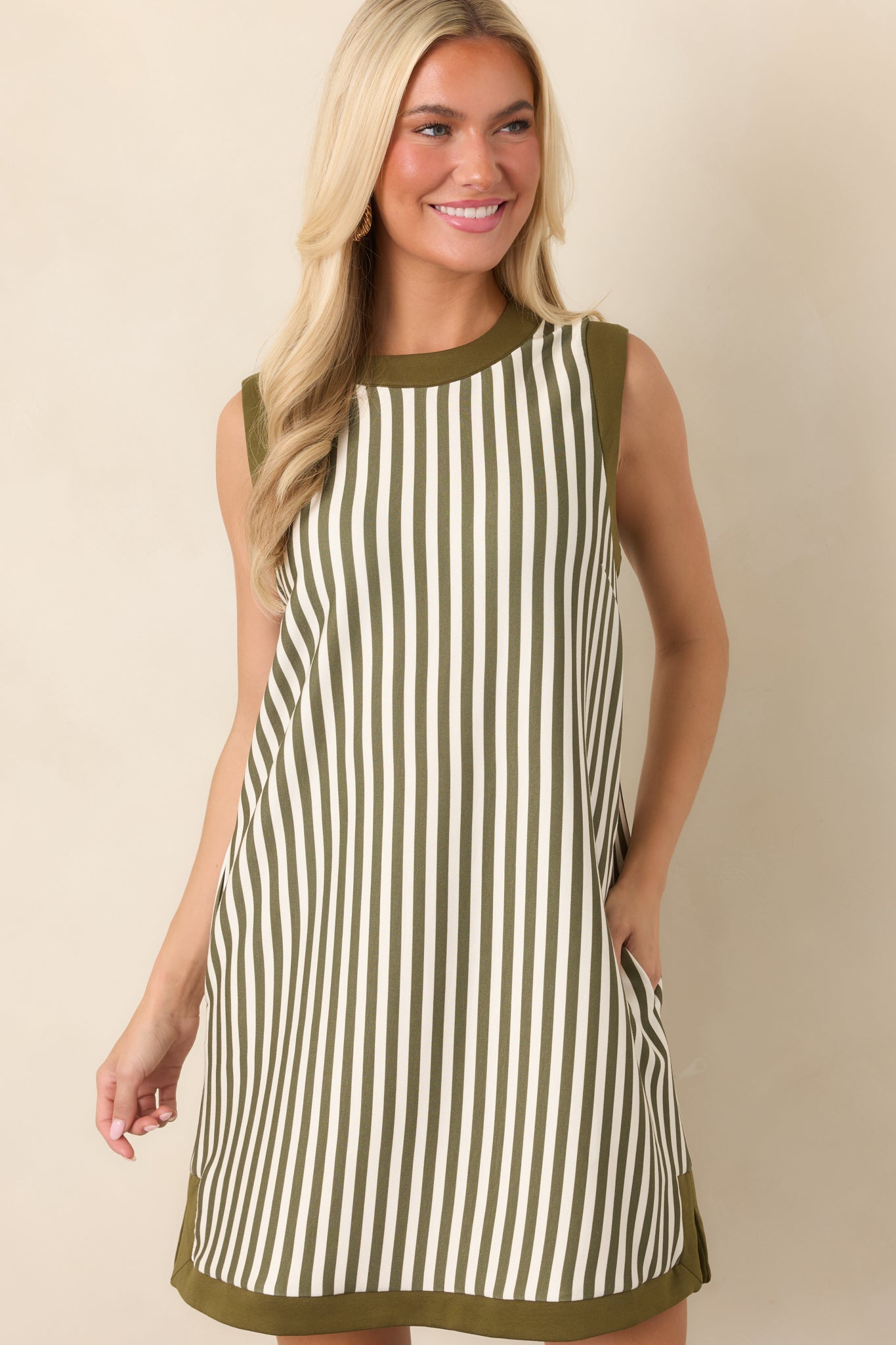 Close view of the olive and ivory vertical stripe pattern, accented by contrasting olive trim along the round neckline.