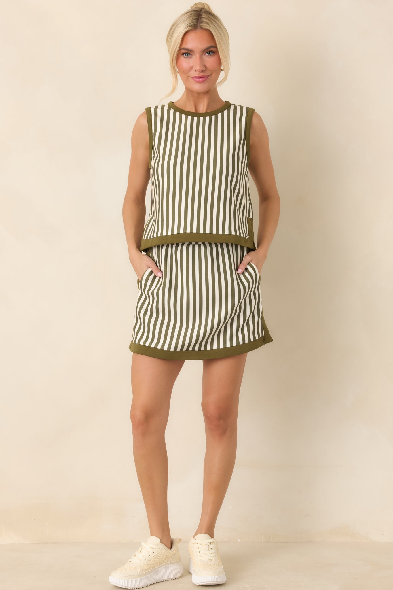 Olive and ivory striped mini skirt designed with a structured high-rise waist, contrast trim, and built-in shorts for added coverage.