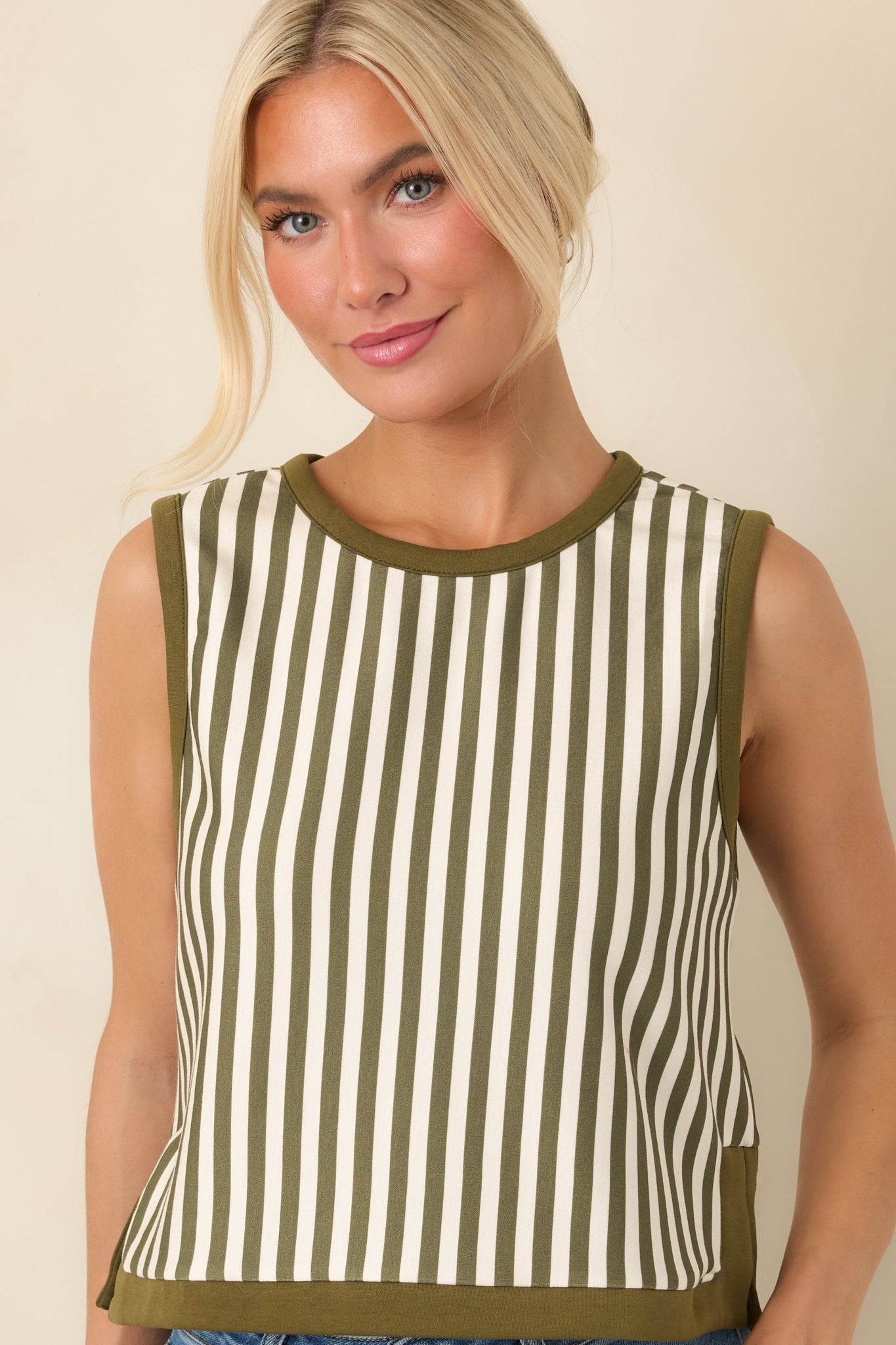 Close view of the olive and ivory vertical stripe pattern, highlighting the round neckline and contrasting olive trim.