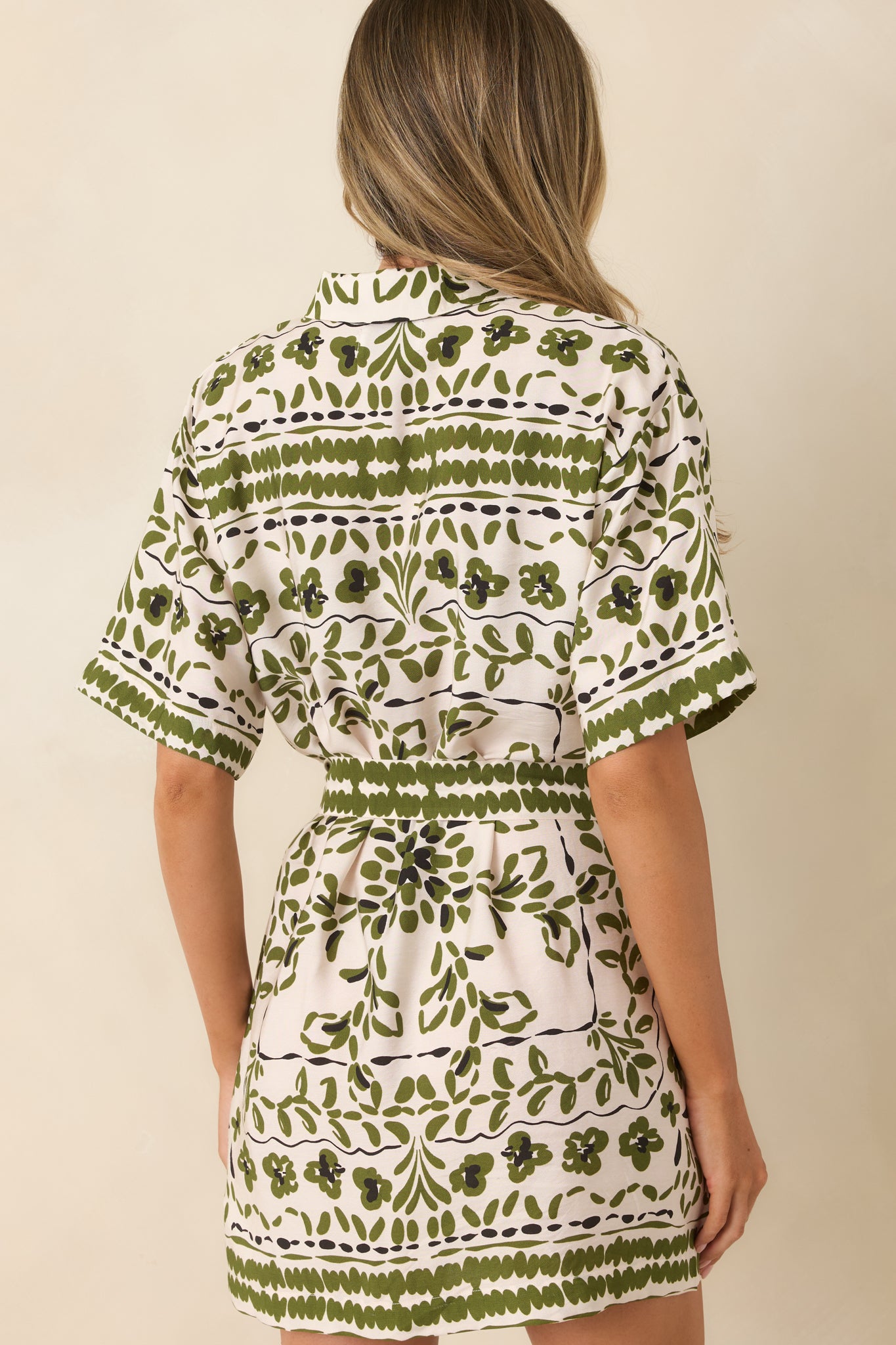 Back of the olive paisley mini dress featuring a relaxed silhouette and removable waist tie detail.