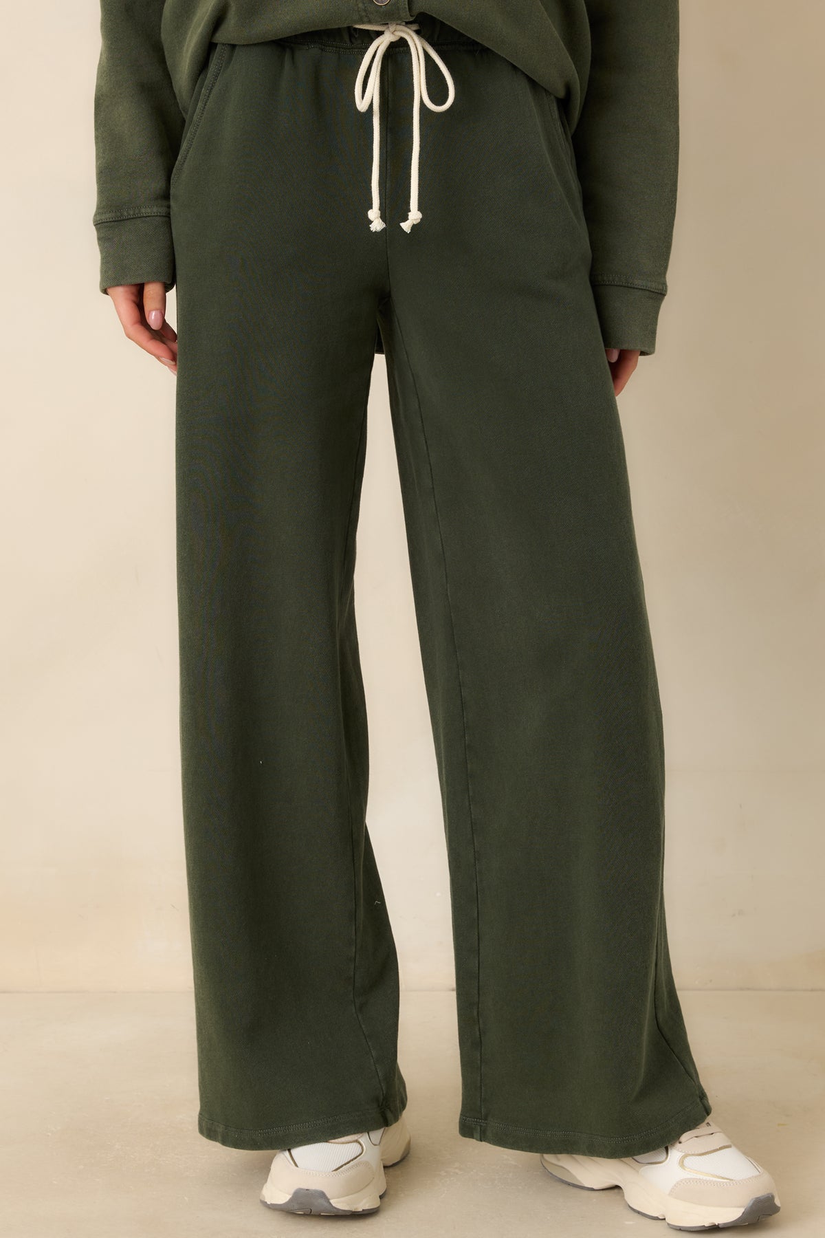 Elastic waistband with a cream adjustable drawstring on the olive green casual pants.