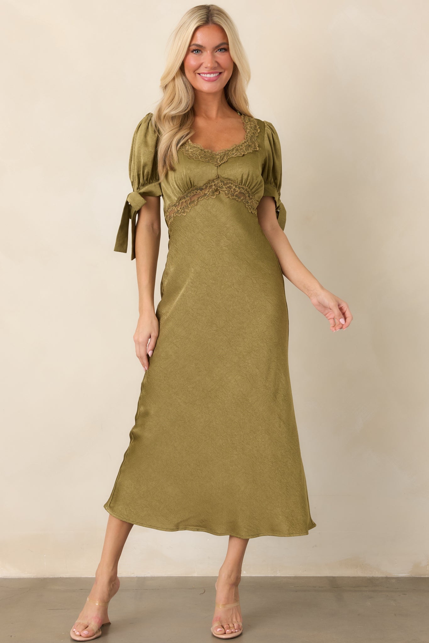 Elegant olive satin dress with delicate lace edging, voluminous puff sleeves, self-tie cuffs, and a softly draped midi silhouette.