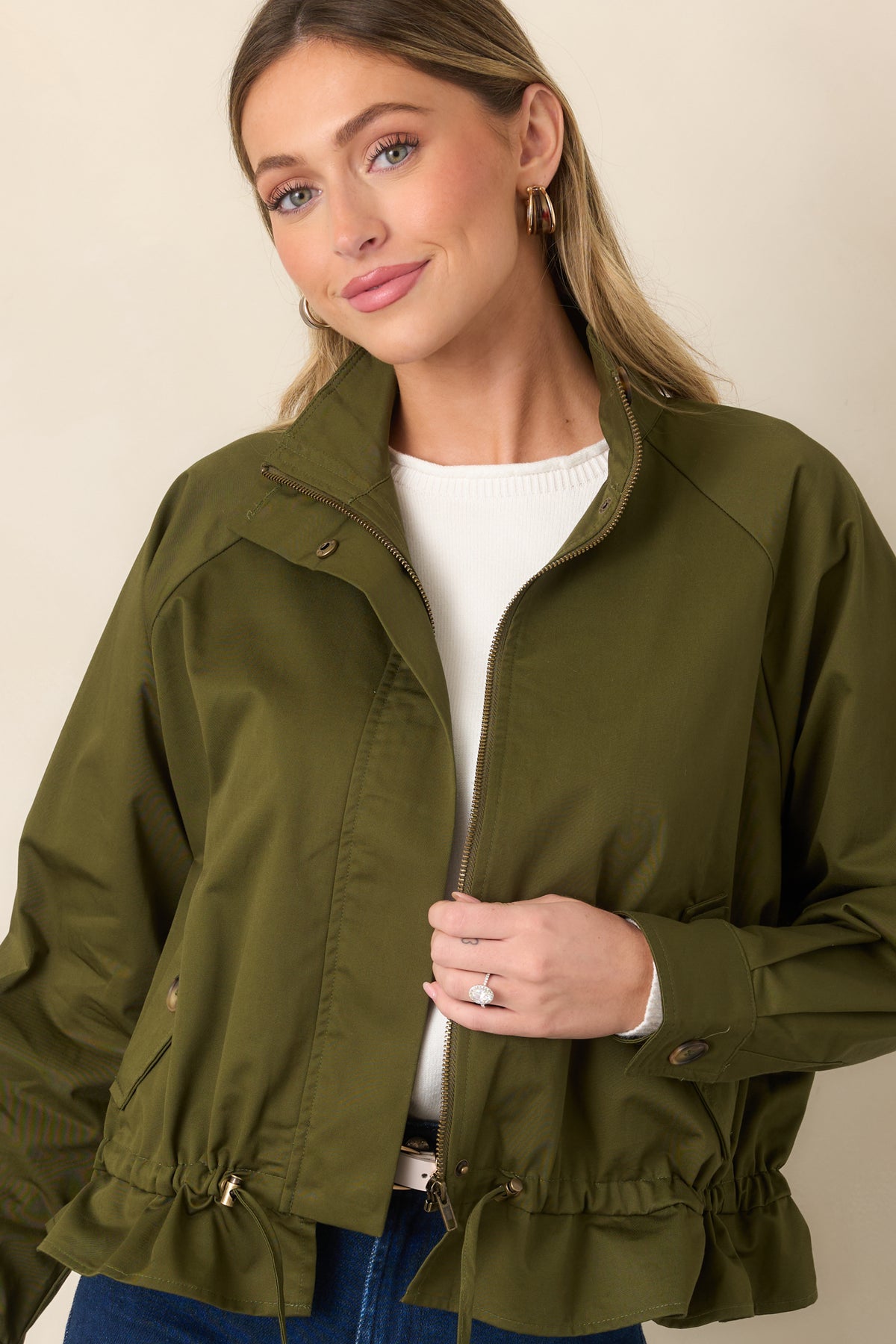 Olive jacket showcasing its stand collar, zip-front closure, and coordinating snap accents