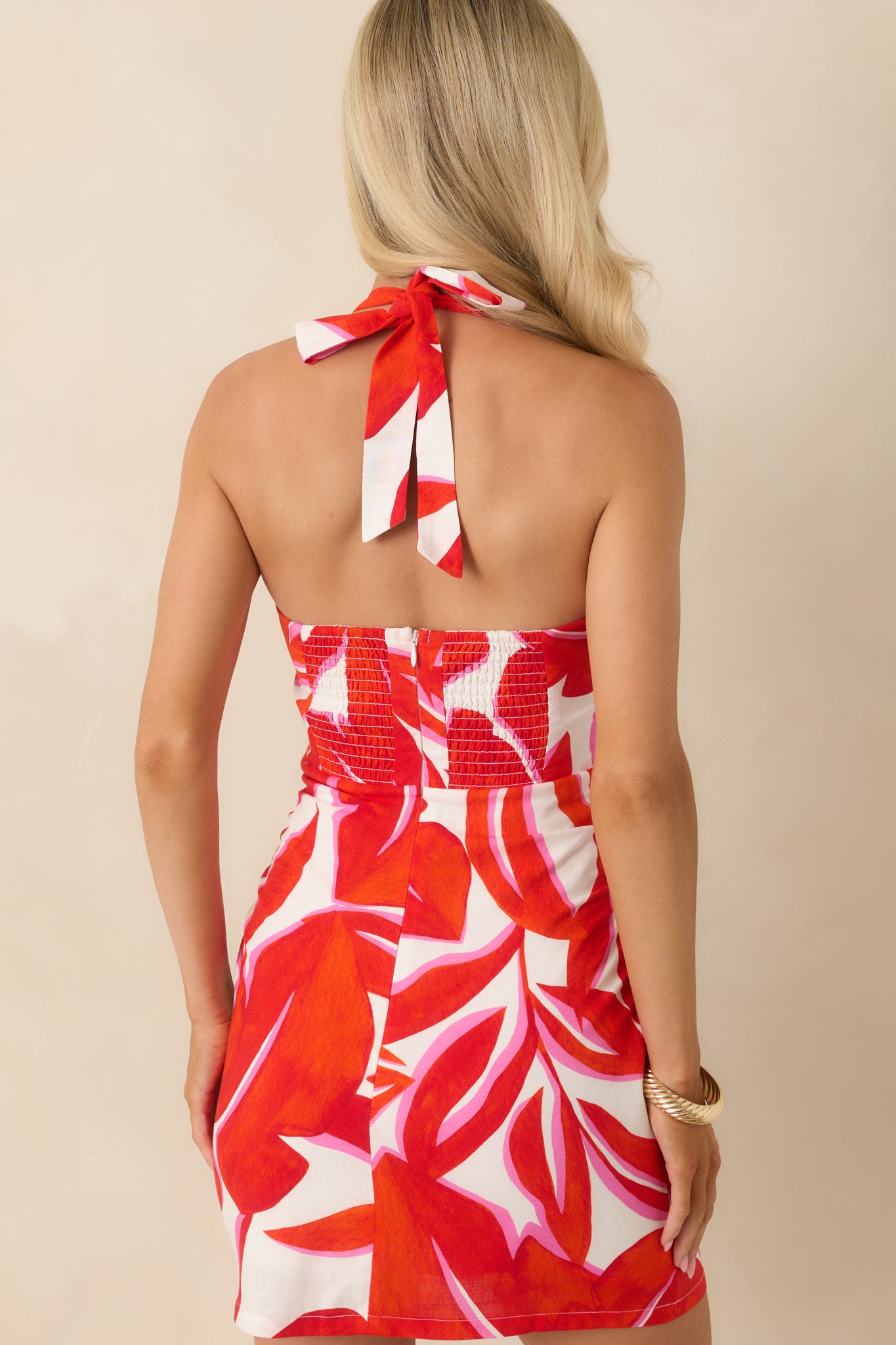 Back view of the mini dress featuring an open-back design with self-tie closure.