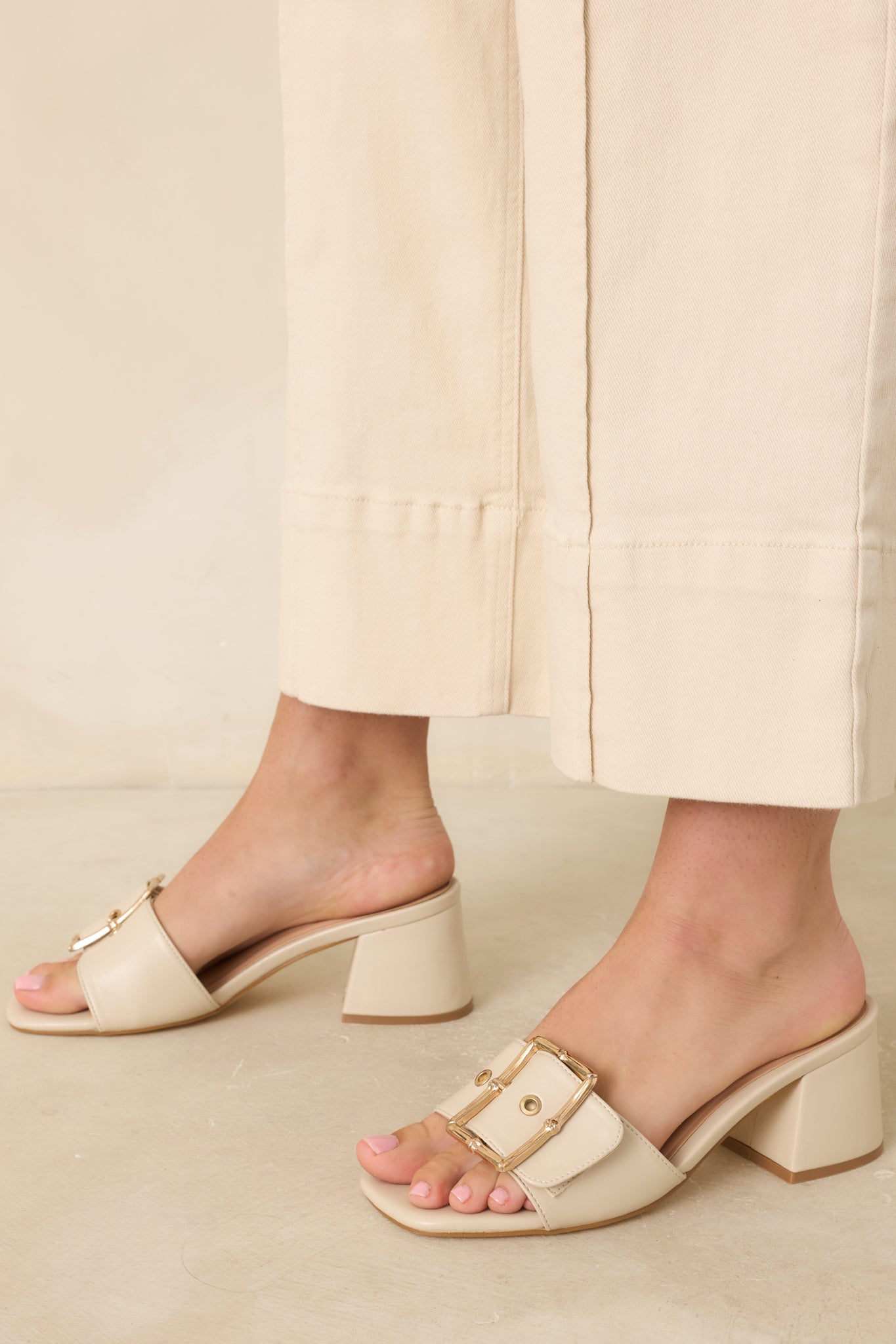 Open-toe slide heels designed with a smooth footbed, comfortable block heel, and elegant buckle detailing.