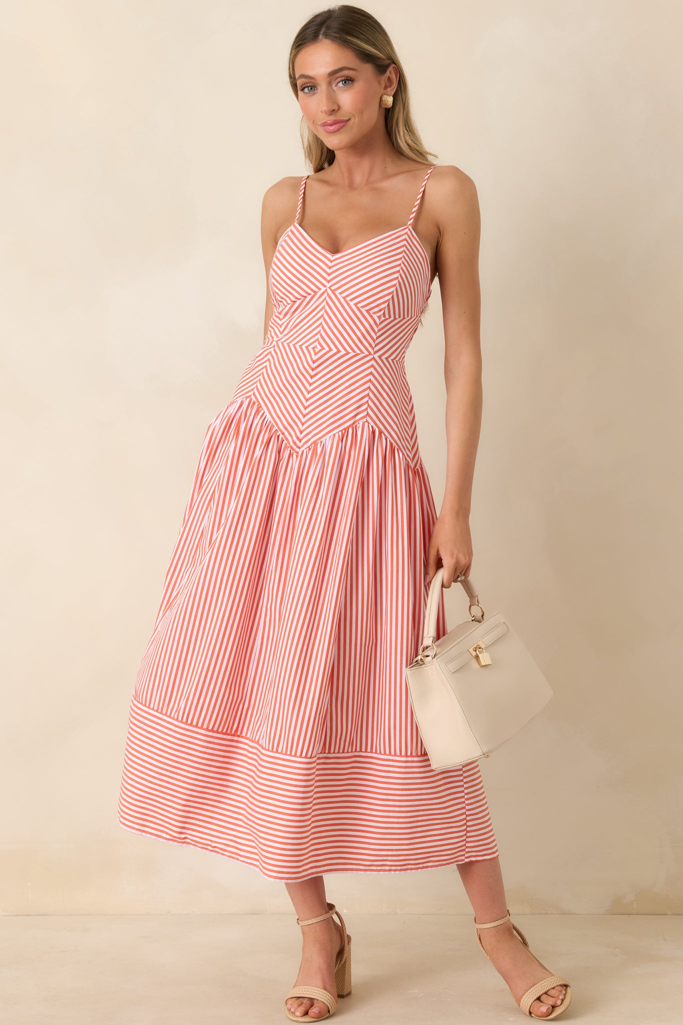 Orange and white striped dress with fitted bodice and flowing midi skirt.