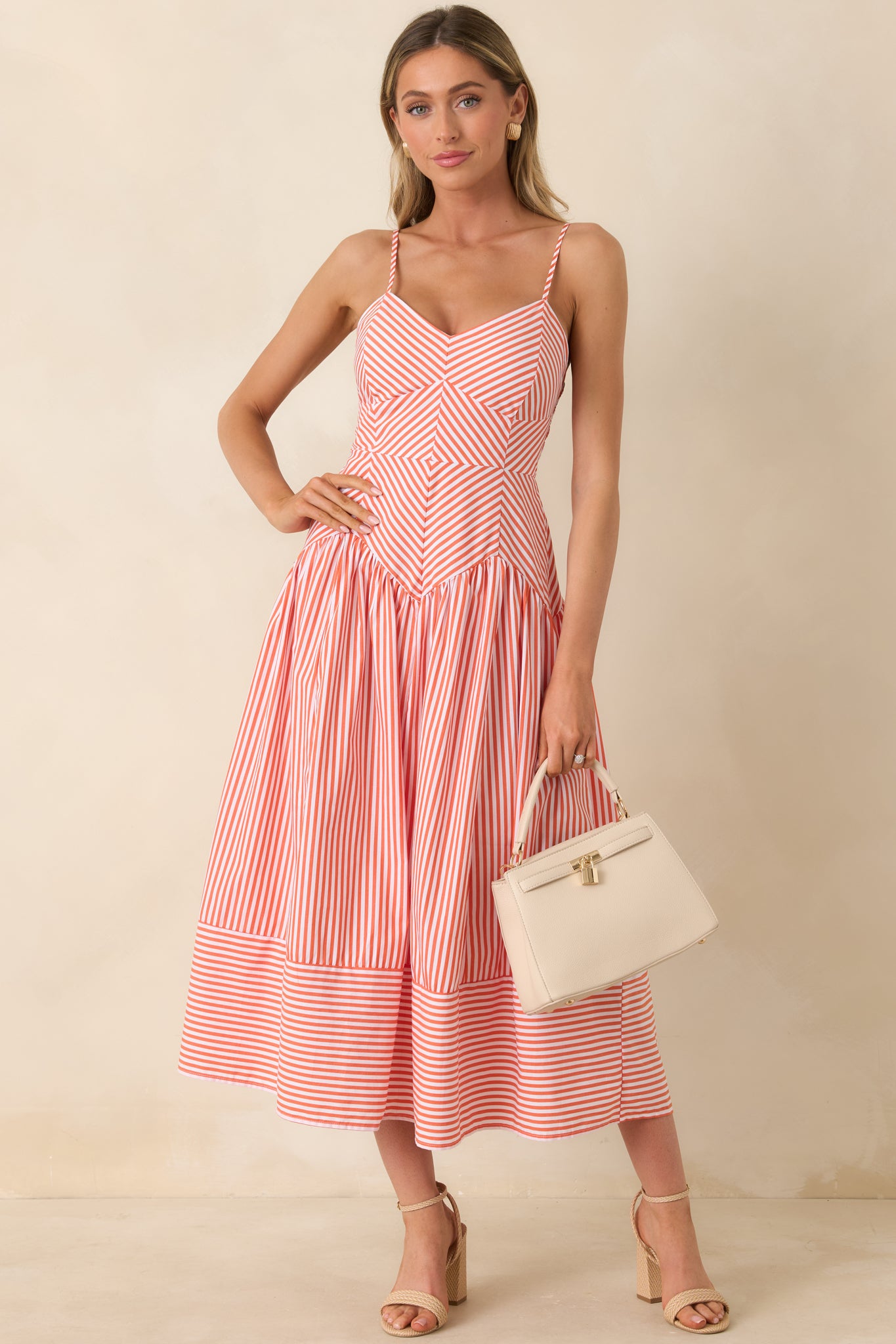Orange and white striped dress with geometric stripe placement and breezy midi skirt.