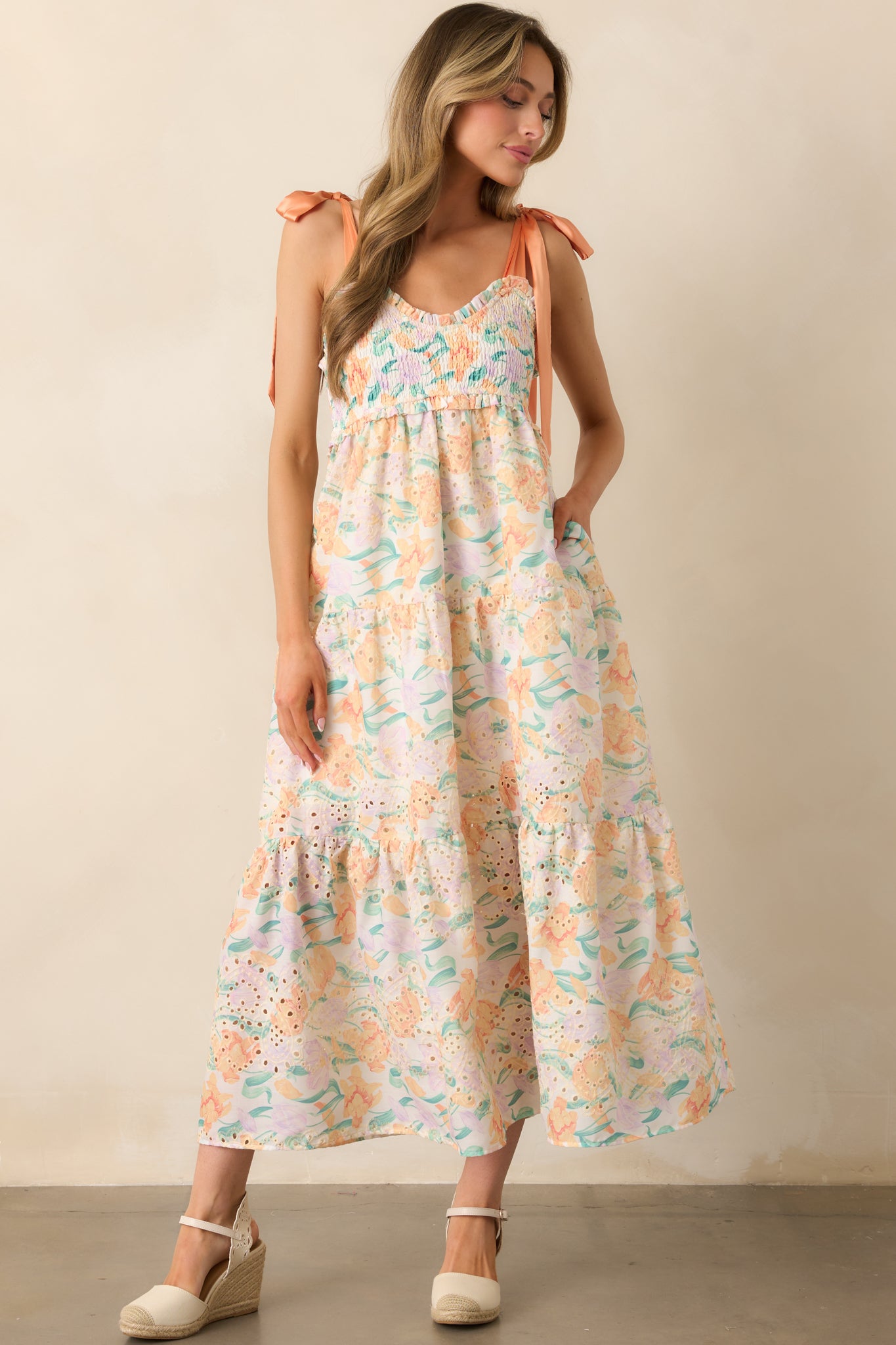 A light orange floral maxi dress with fully smocked bust, ruffle trim, and ivory lining, designed to flatter and move with ease.