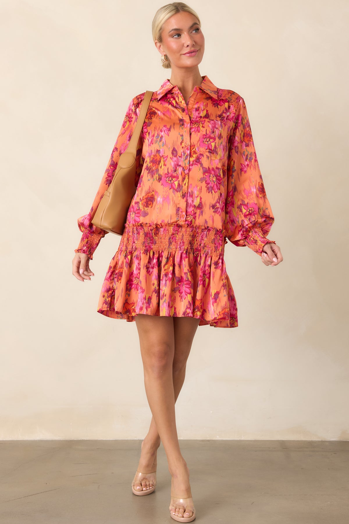 Orange multi floral satin dress showcasing its silky sheen, button-front collar, voluminous balloon sleeves, smocked waist, and playful mini length.