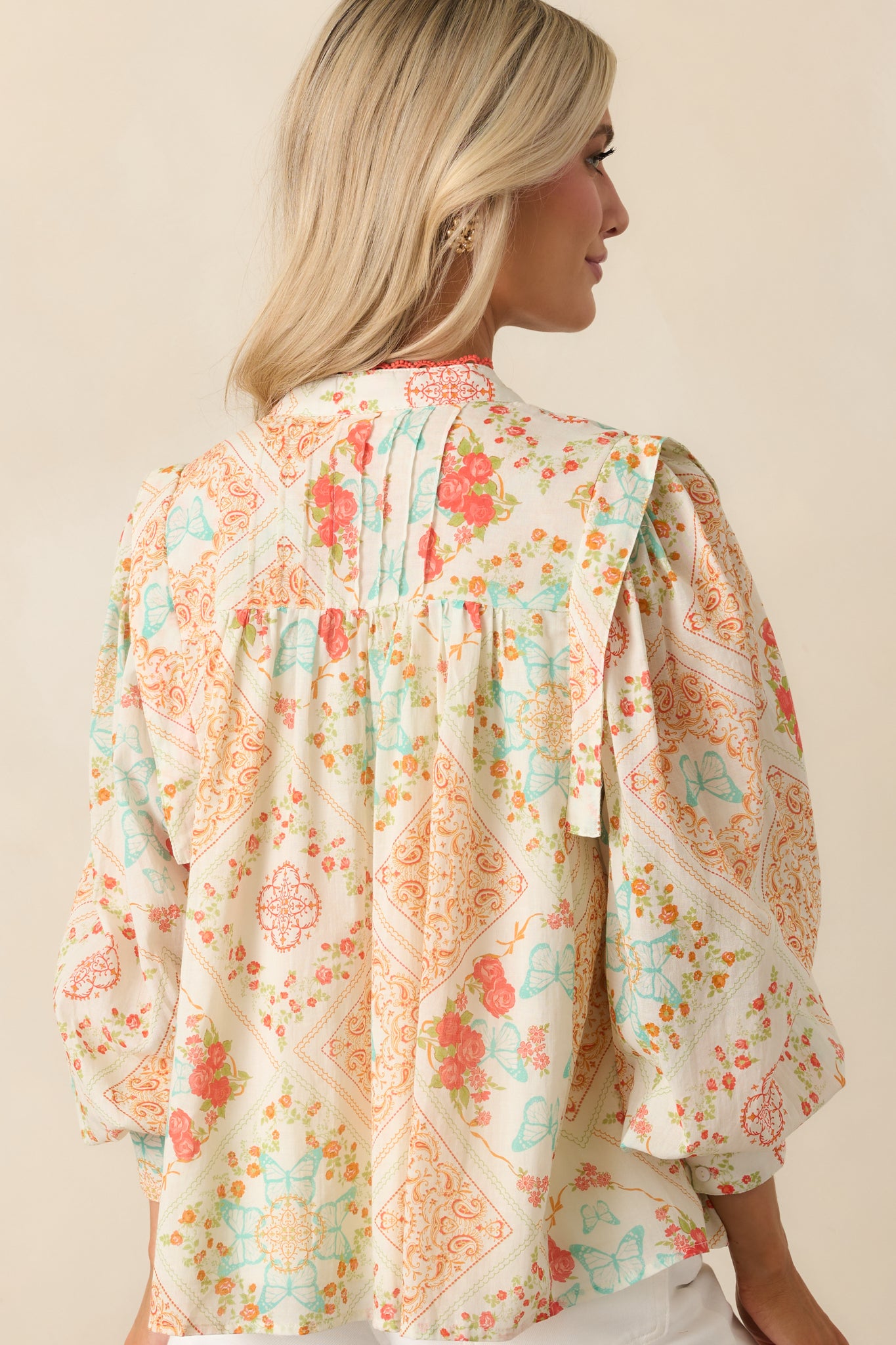 A back view of the orange top, revealing the full patchwork design and softly gathered back yoke.