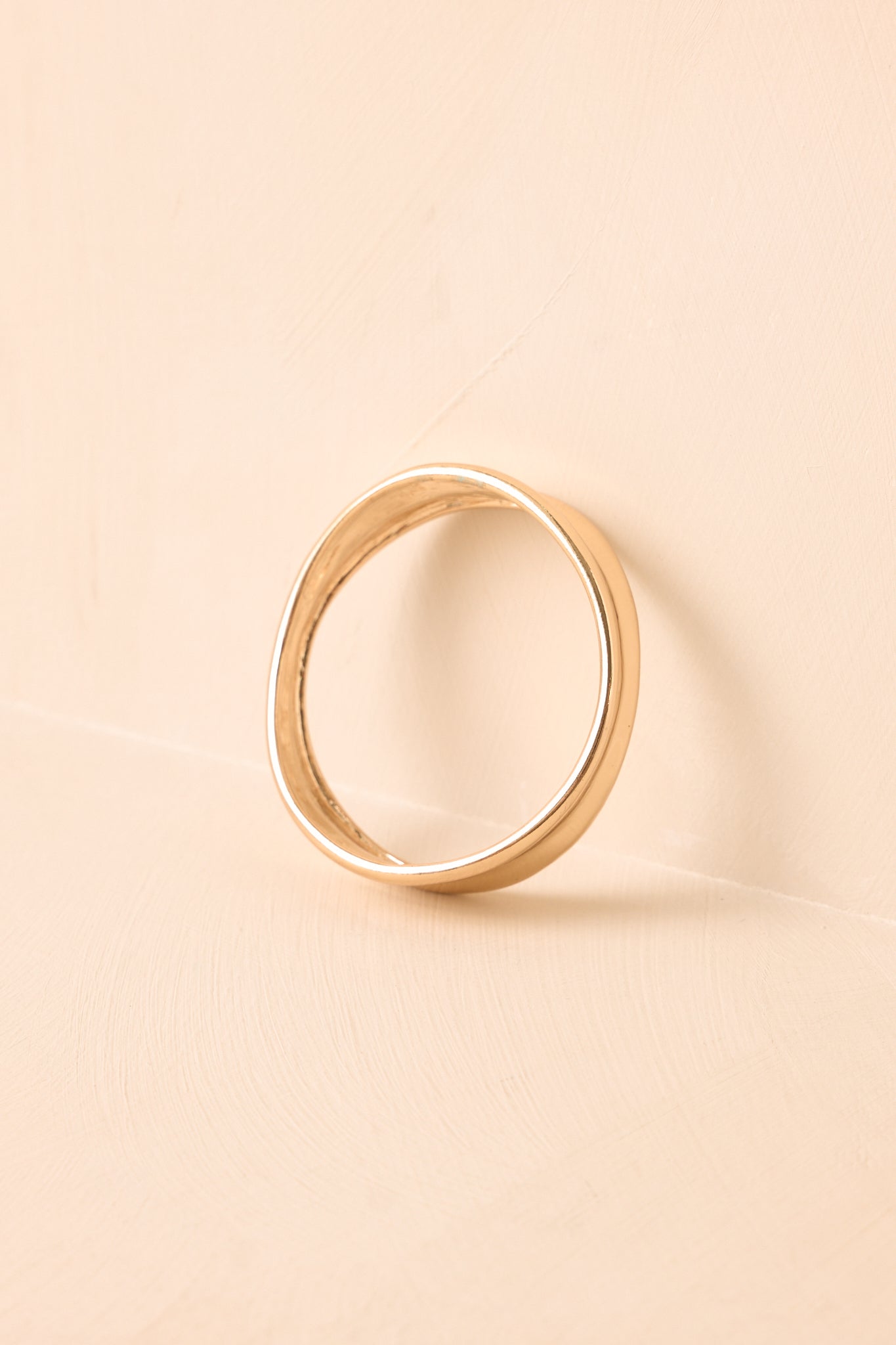 Organic-shaped bracelet presented on a neutral backdrop, emphasizing its fluid silhouette and modern elegance.