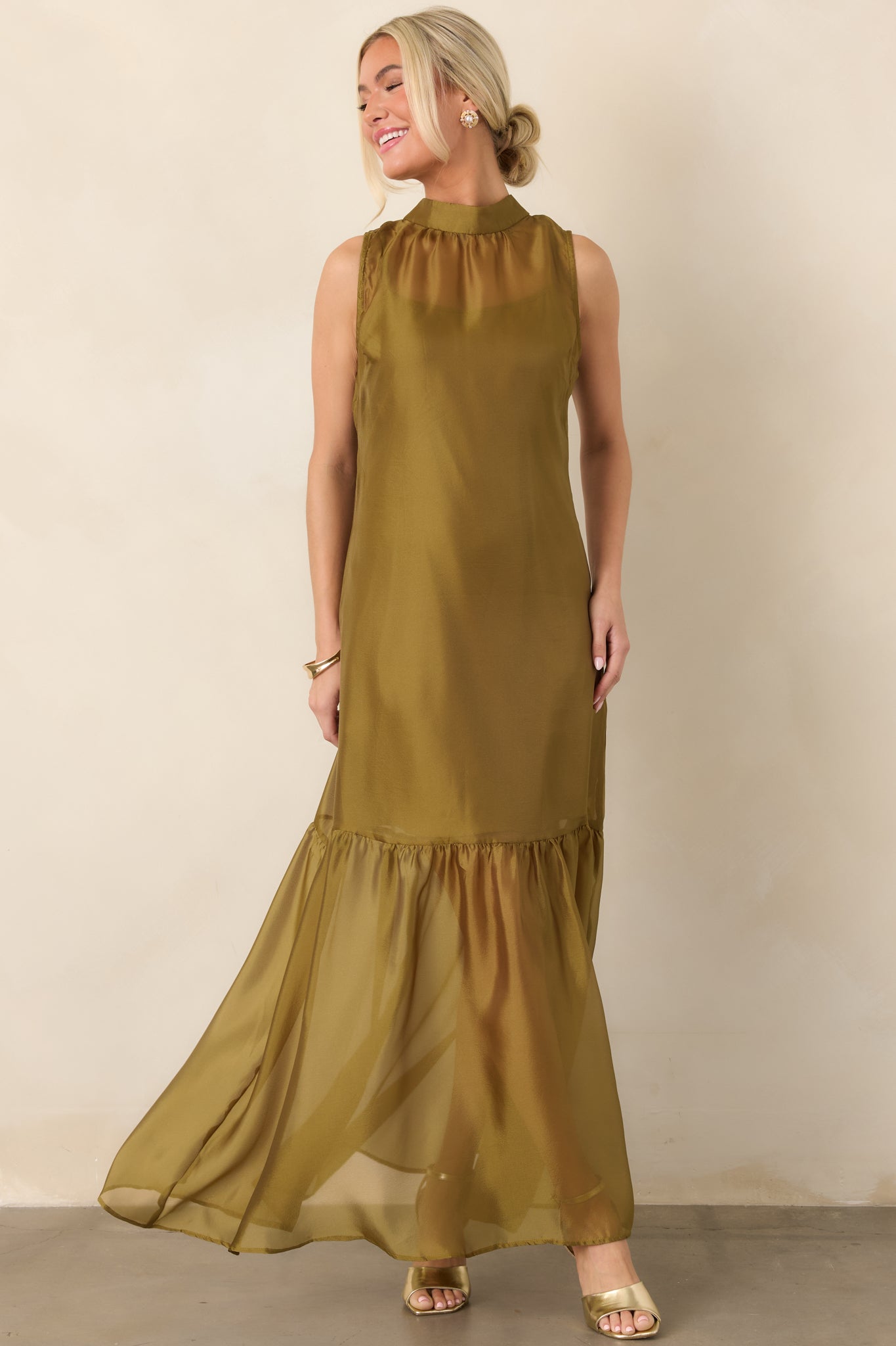 Ethereal organza maxi dress designed with a graceful flowing shape, high neckline, sheer skirt overlay, and softly gathered lower hem.